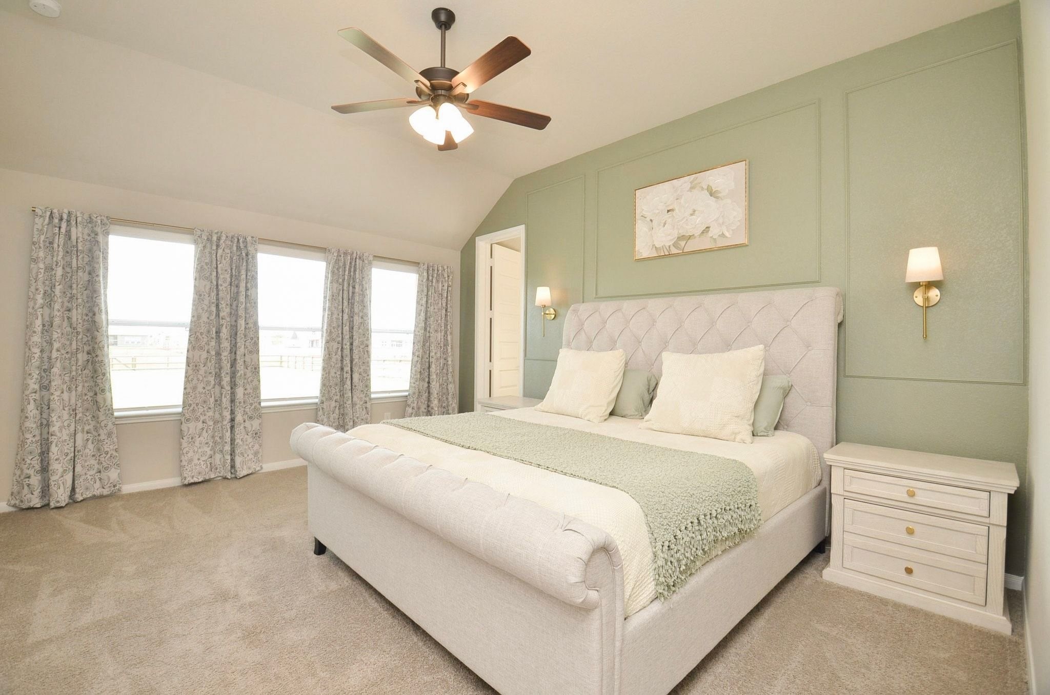 Spacious primary bedroom with a wall of windows and gorgeous accent wall