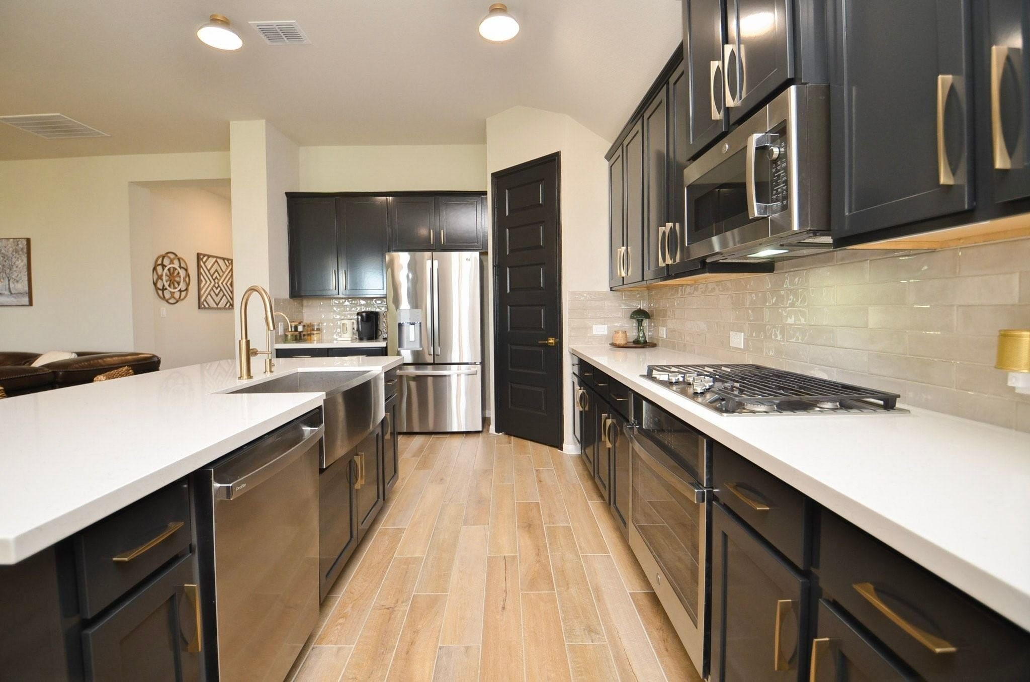 Stainless steel farmhouse style sink, gas cooktop, and stainless steel appliances- refrigerator stays!