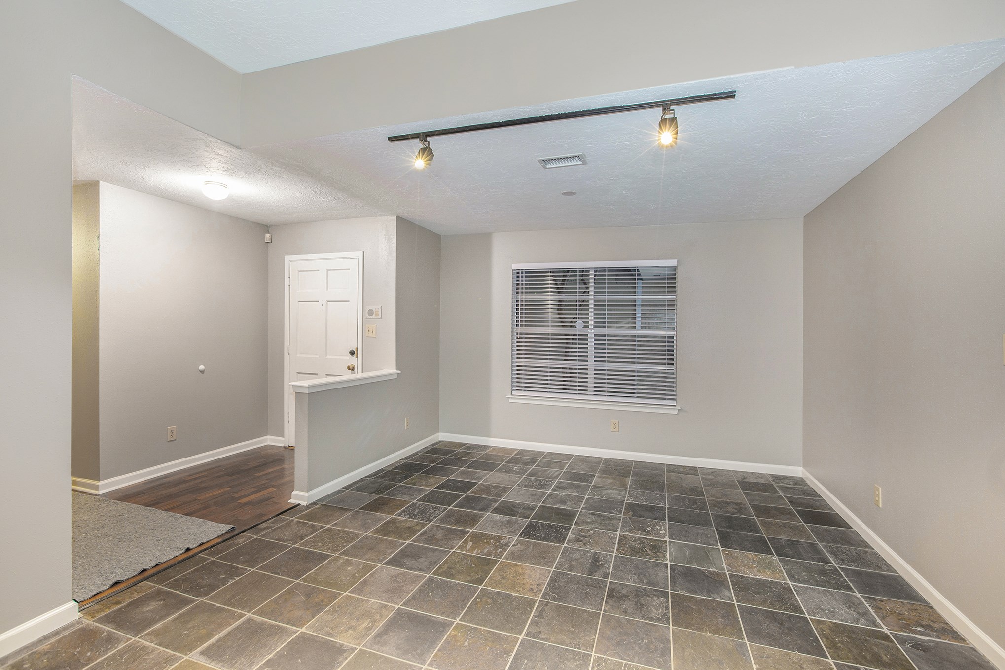 Dining room with track lighting and slate floor. Dining room with track lighting and slate floor.