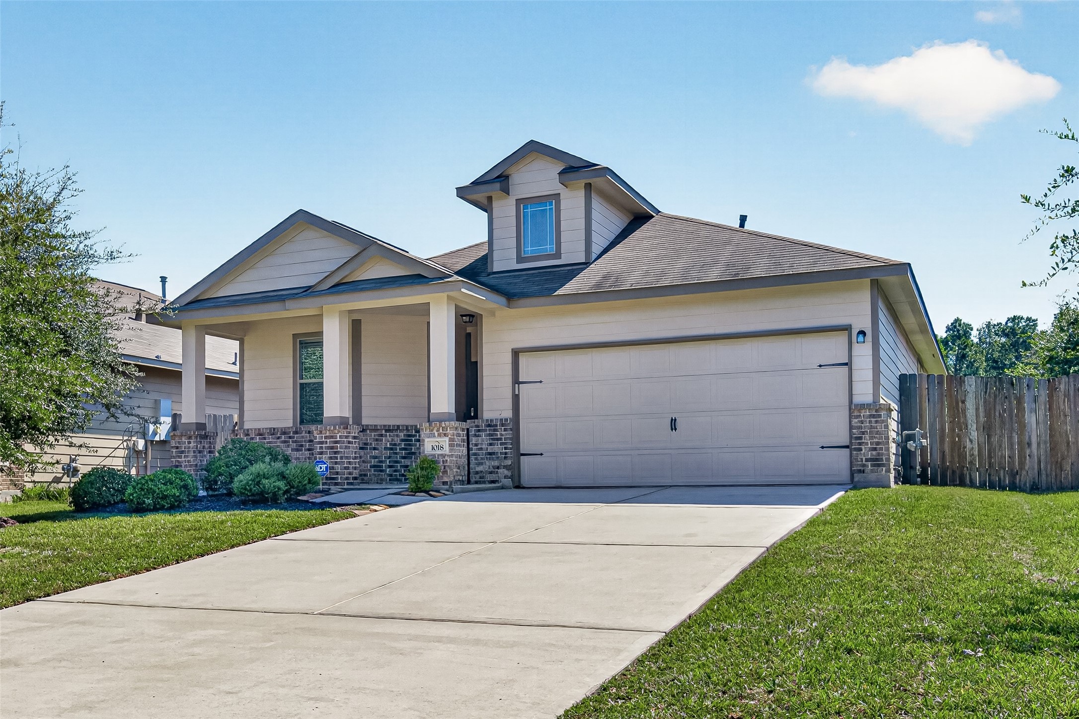 Classic brick accents and a welcoming front porch give this home a warm, attractive exterior