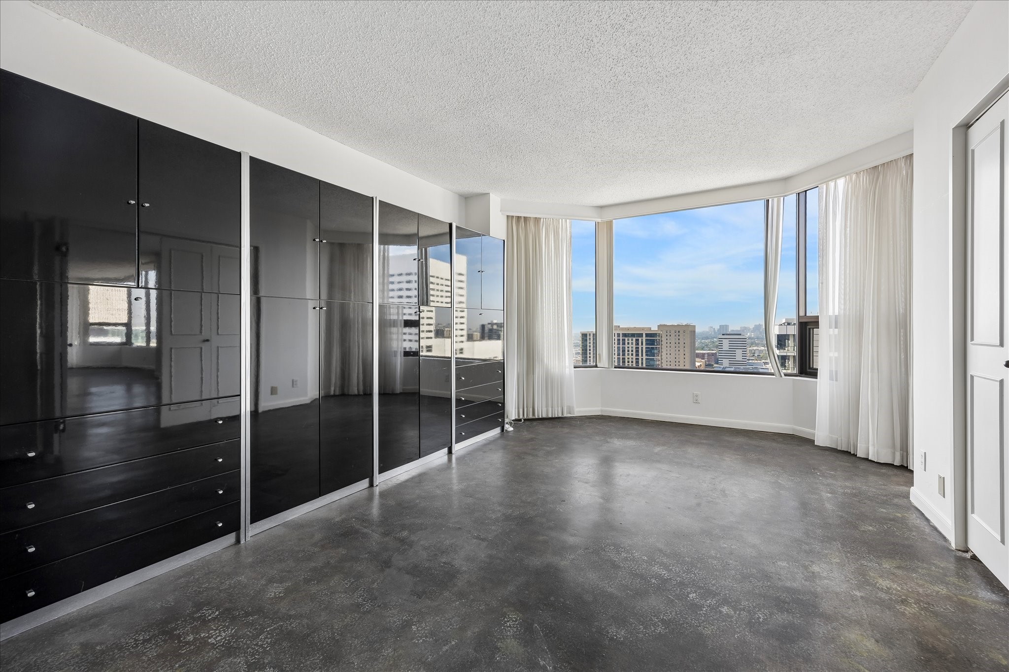 Double doors allow this flexible room to open to the adjoining living area or close for added separation. Concrete flooring and a broad window bay make it well suited for a study, reading room or additional living space.