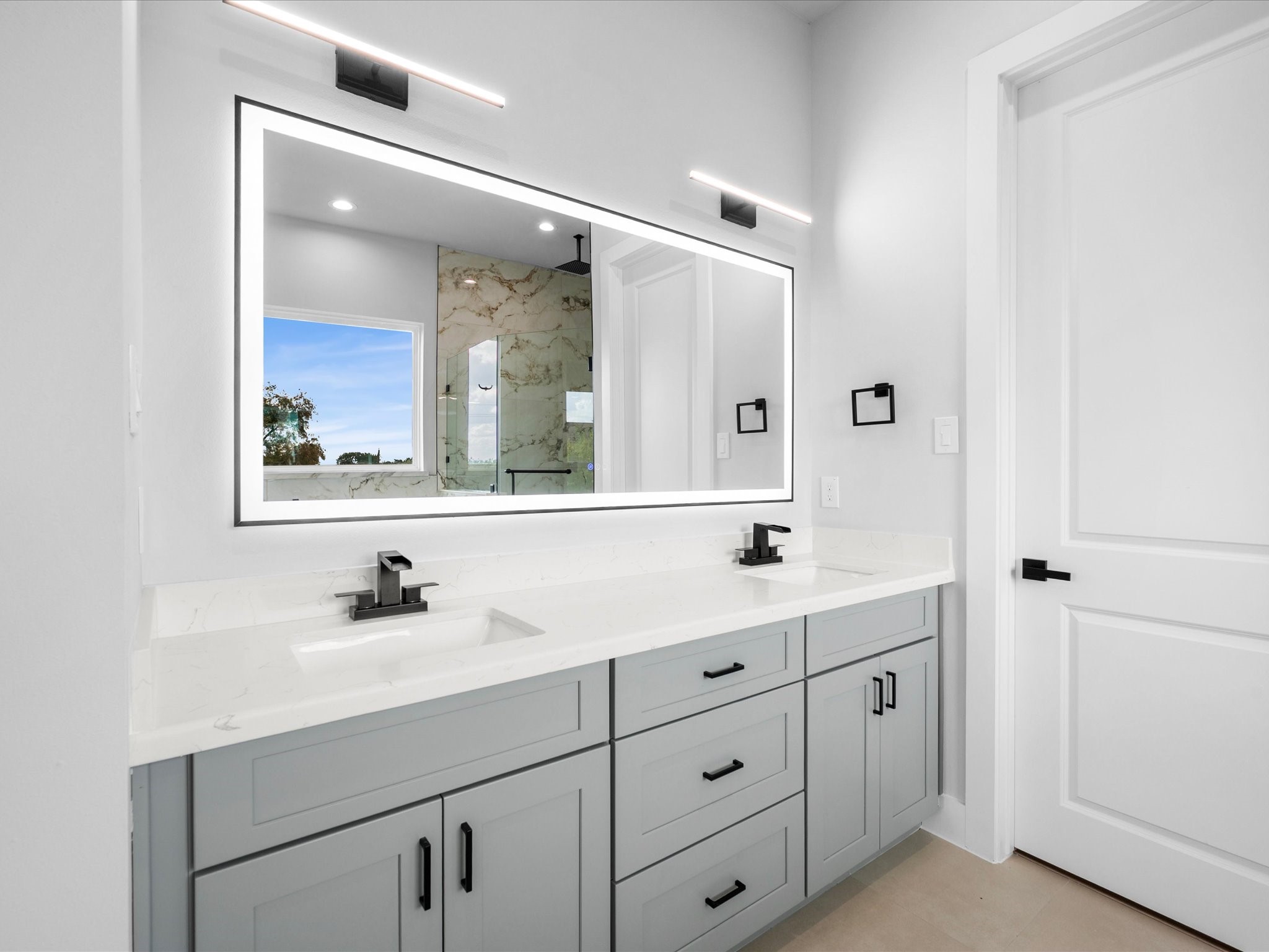 Designed with relaxation in mind, the primary ensuite pairs elegant tile details with striking lighting and sophisticated finishes for a spa-inspired feel.