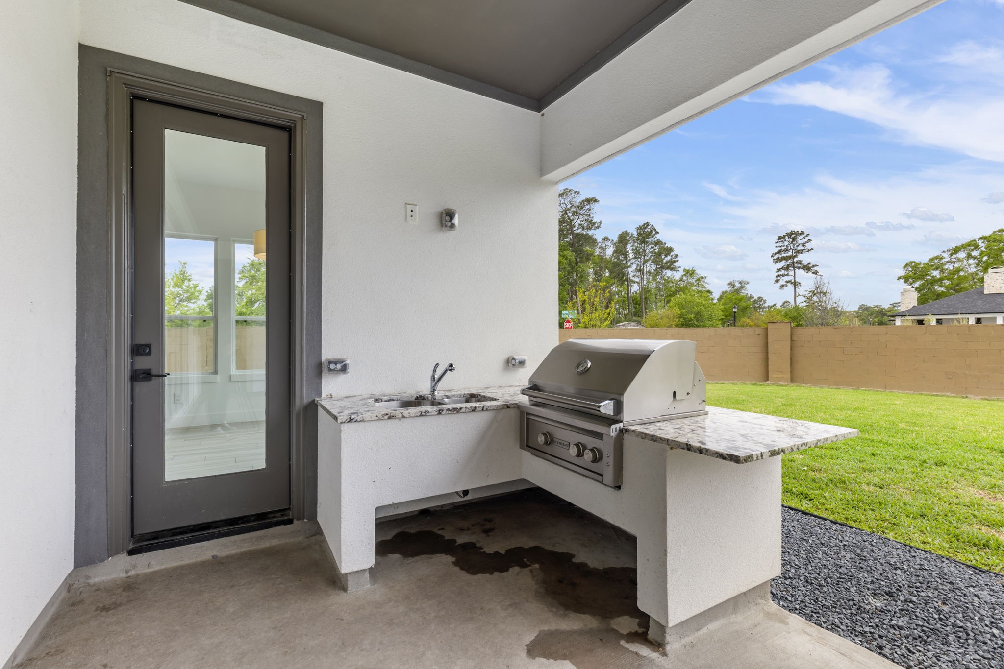 Outside grill and sink with granite countertops.