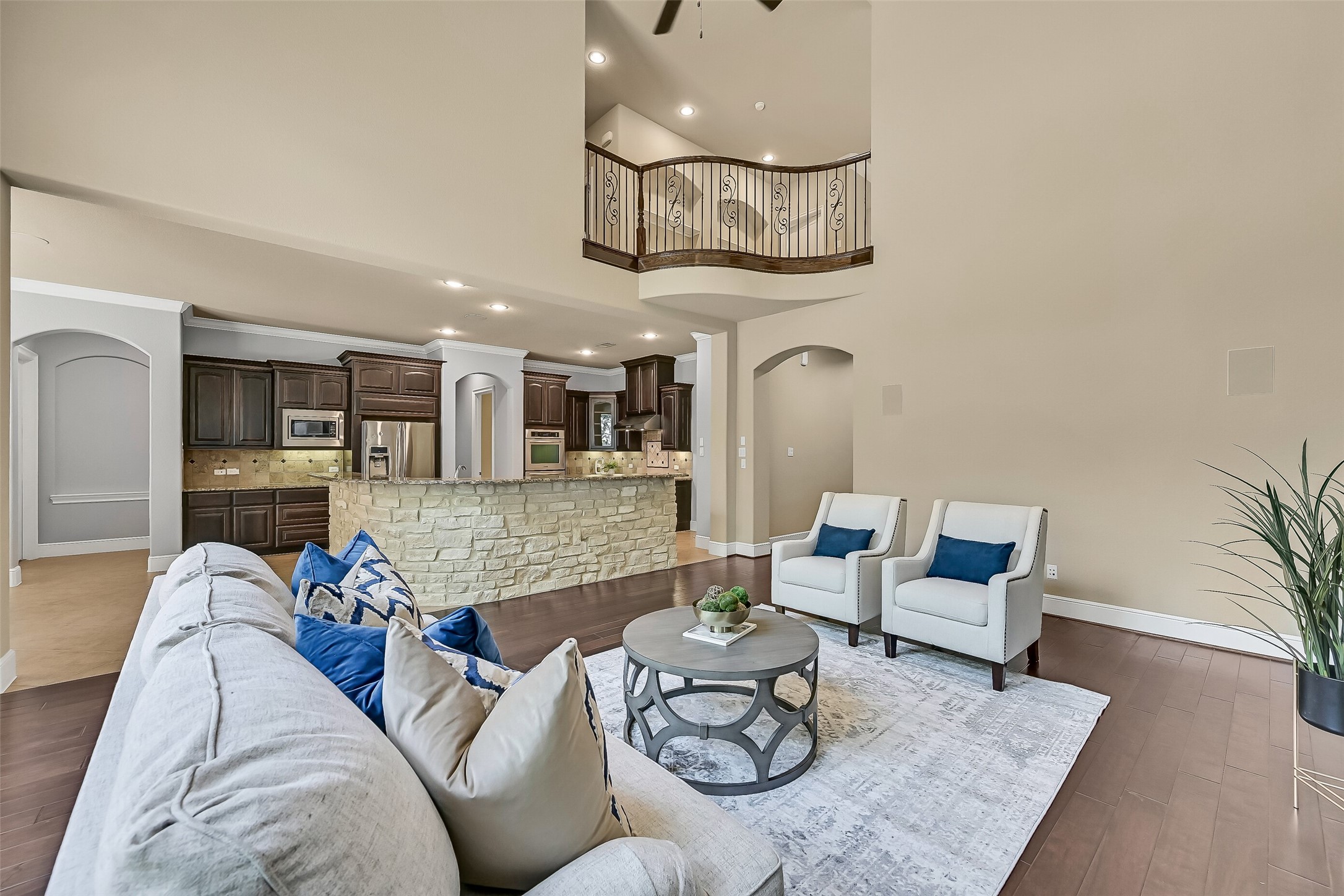 From the family room, the homes open-concept layout really comes into focus with sightlines into the kitchen, breakfast room, and upstairs landing, while the sweeping stone breakfast bar creates a natural gathering space at the heart of the home.