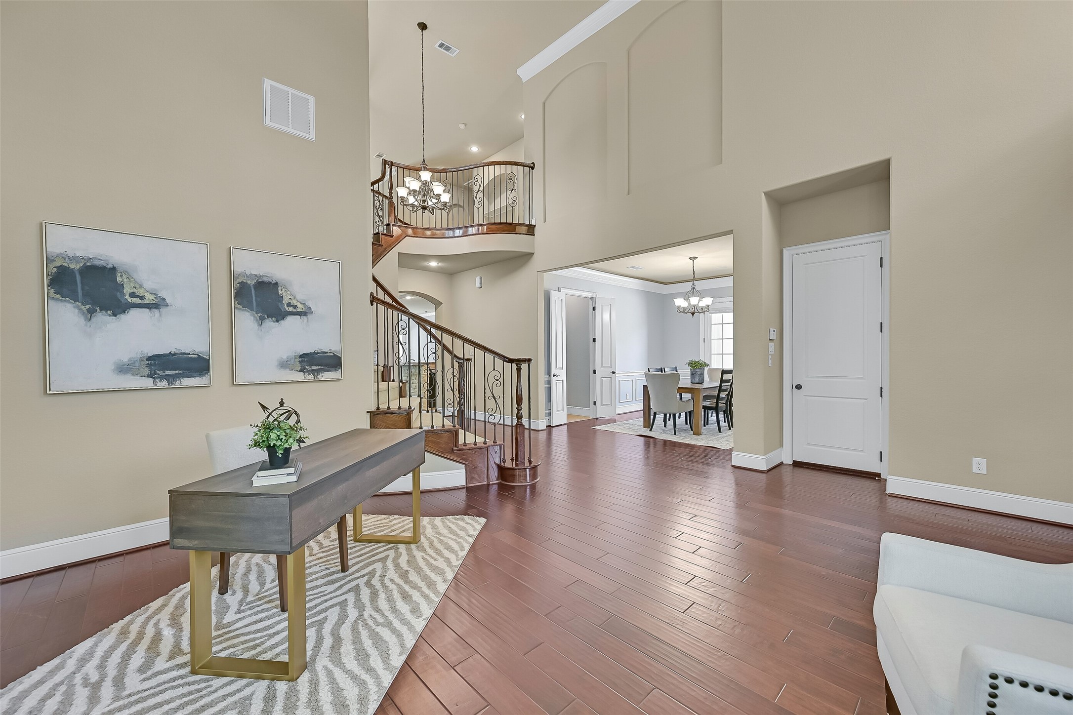 From the formal living room, the homes thoughtful layout begins to unfold with sightlines into the foyer, dining room, and family room beyond. The rounded wall of windows, elevated plant ledge, and expansive wood flooring make this space feel both grand and inviting.