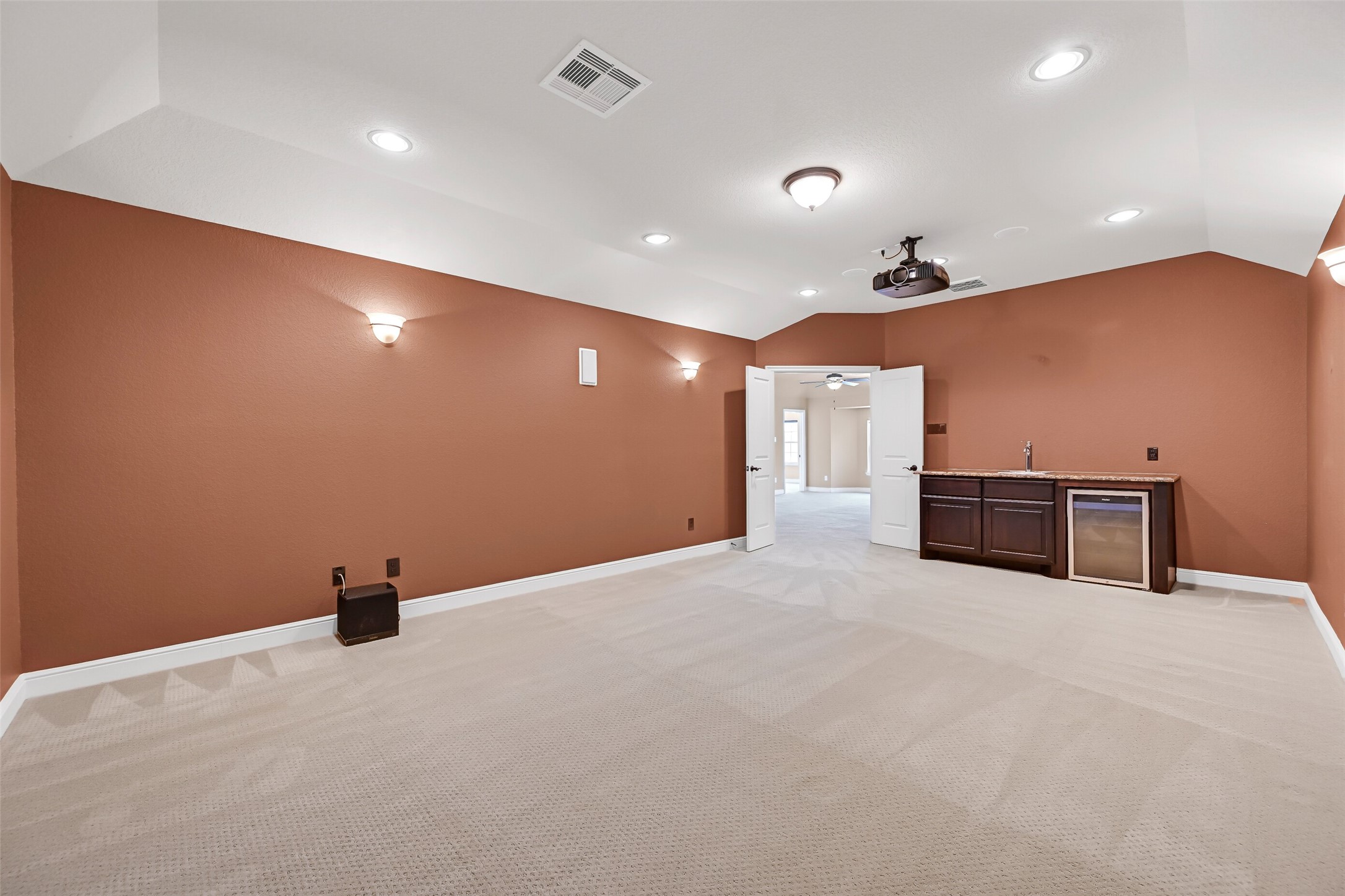 This spacious media room also includes a convenient wet bar with granite countertops, cabinetry, a beverage fridge, and room for snacks and drinks, making it ideal for hosting movie marathons or game day watch parties.