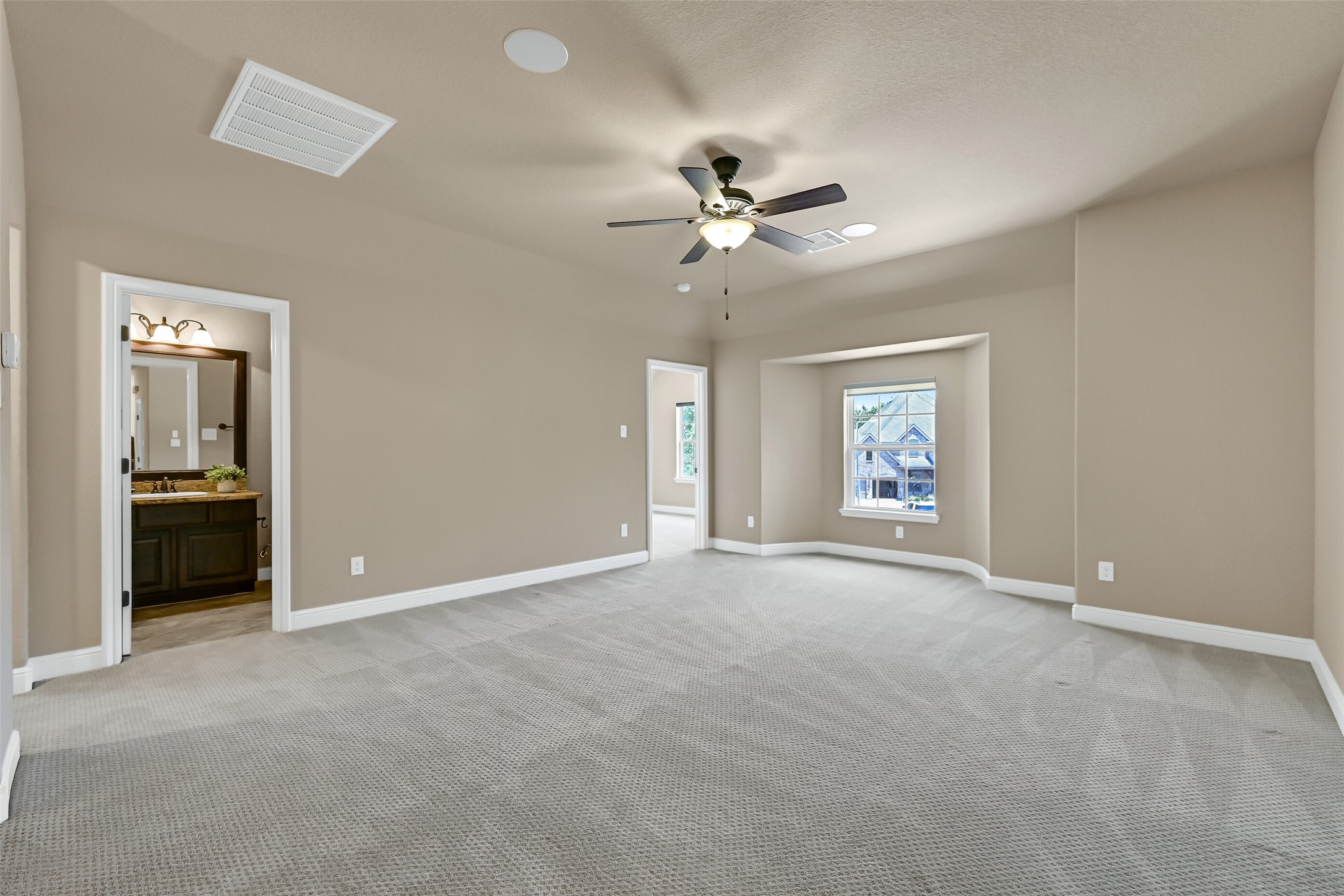 Upstairs, the oversized game room offers endless flexibility for play time, gaming tables, a pool table, or a second living area, all with plush sculpted carpet, built-in speakers, and plenty of room to spread out. A full bathroom is also accessible from this space.