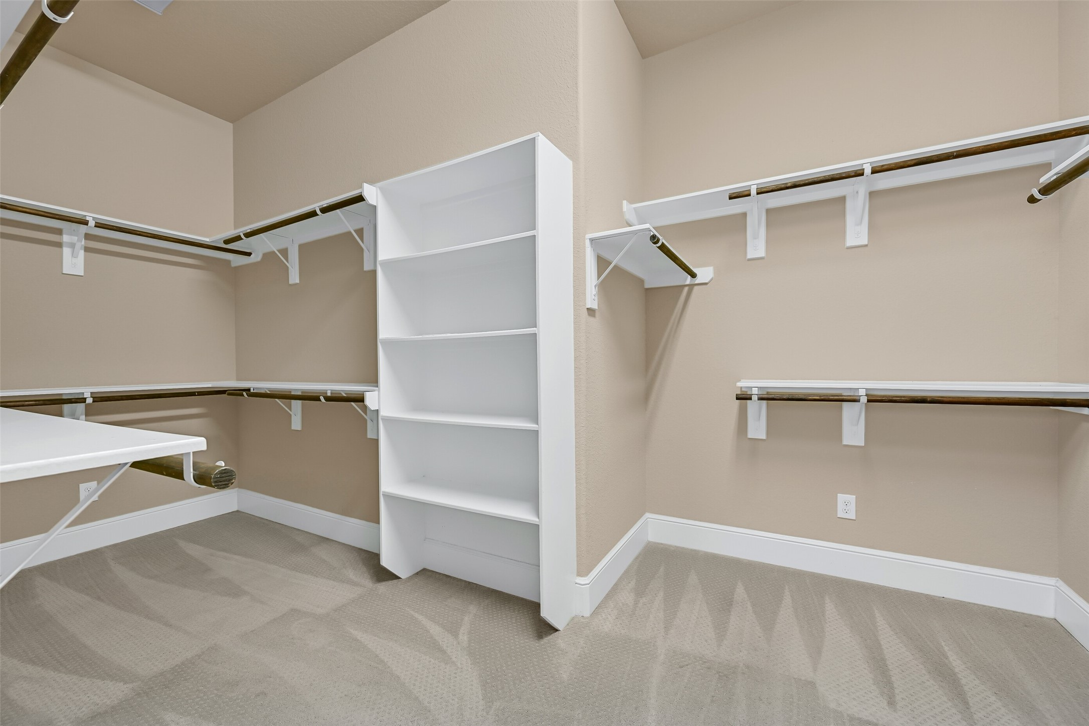 One of two enormous walk-in closets in the owners suite offers extensive hanging space, built-in shelving, and room for seasonal storage, making organization effortless while complementing the suites impressive scale.