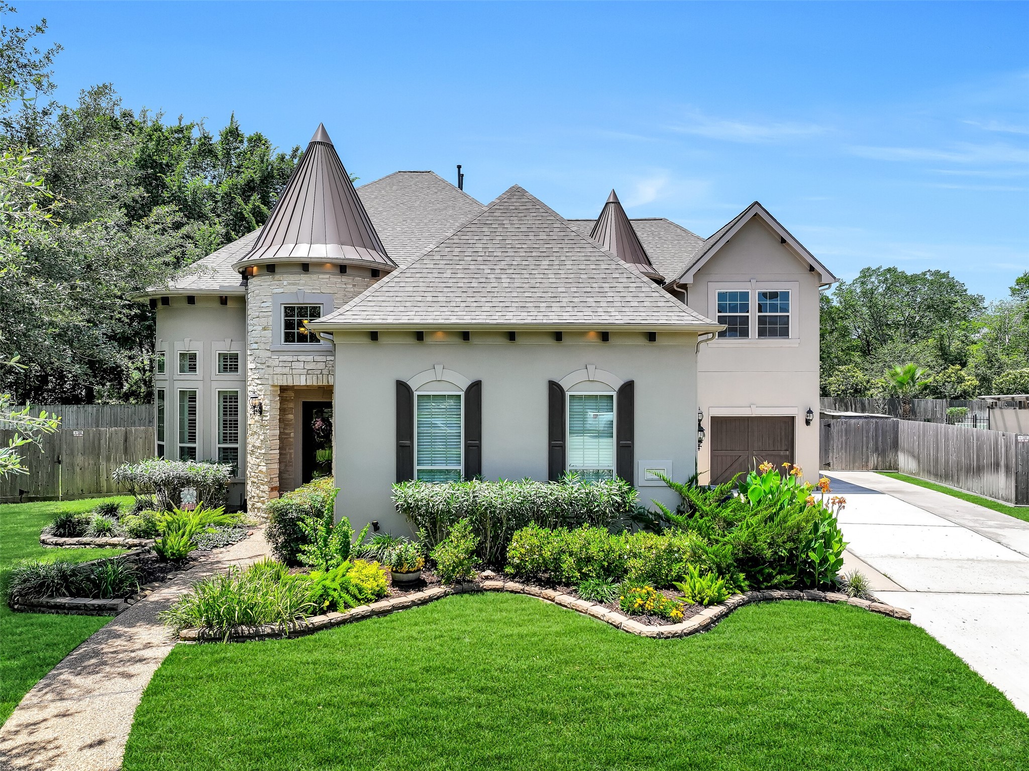 Tucked away on a beautifully landscaped cul-de-sac lot in West Ranch, this custom stucco home immediately stands apart with its stone turret accents, dramatic metal rooflines, carriage-style garage doors, lantern lighting, and meticulously maintained grounds that create unforgettable curb appeal from the street.