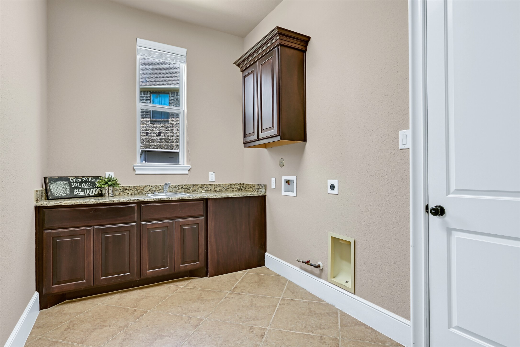 Just off of the kitchen, the spacious utility room offers a granite folding counter with a utility sink, upper cabinetry, tile flooring, and space for a full-size washer and dryer. The door opens to the single bay garage space that's perfectly suited for parking, storage, or a home gym.
