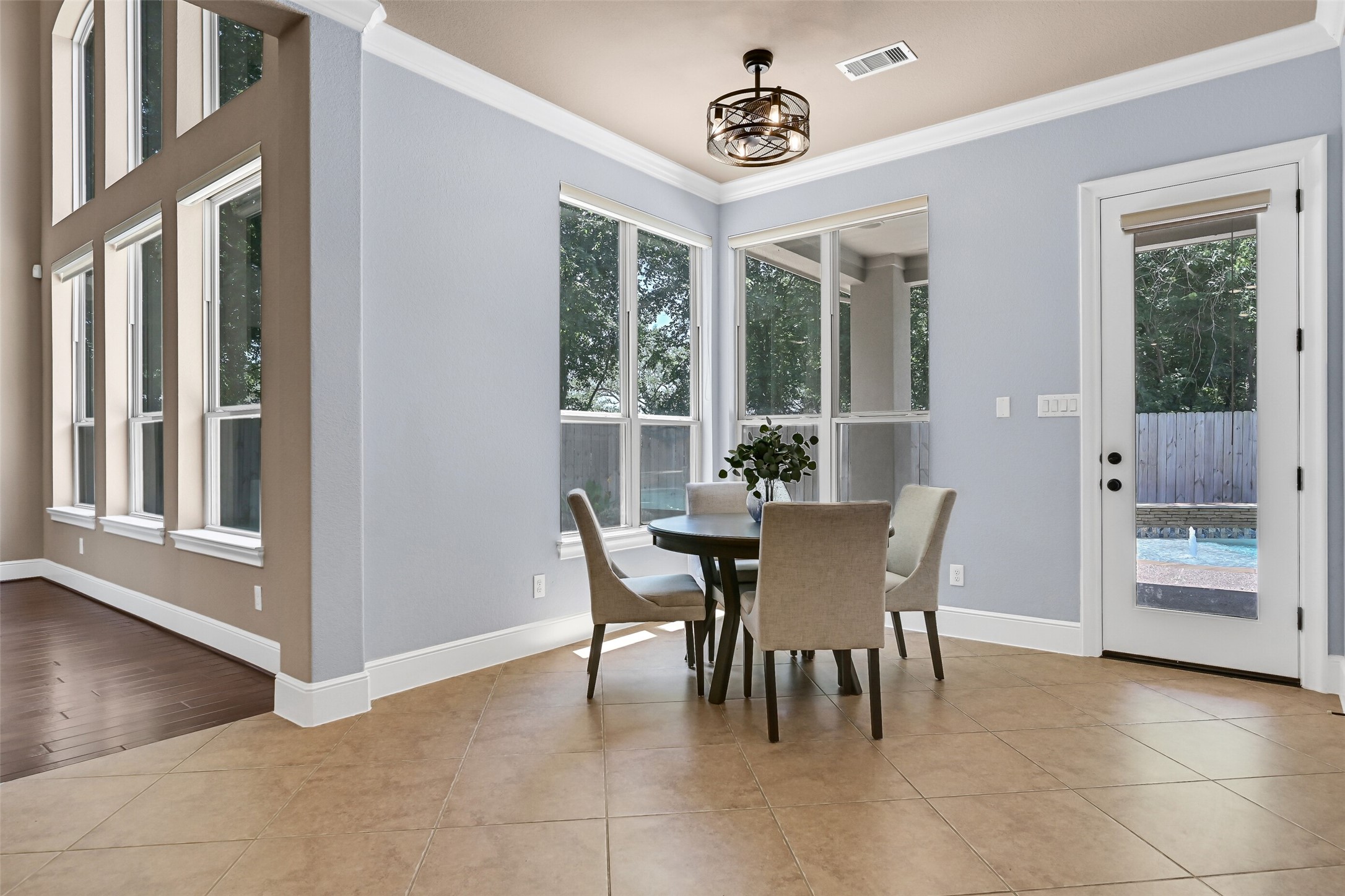 The breakfast room is surrounded by windows overlooking the backyard and pool area, creating a bright and cheerful casual dining space with direct access to the covered patio through the 8-foot glass door.