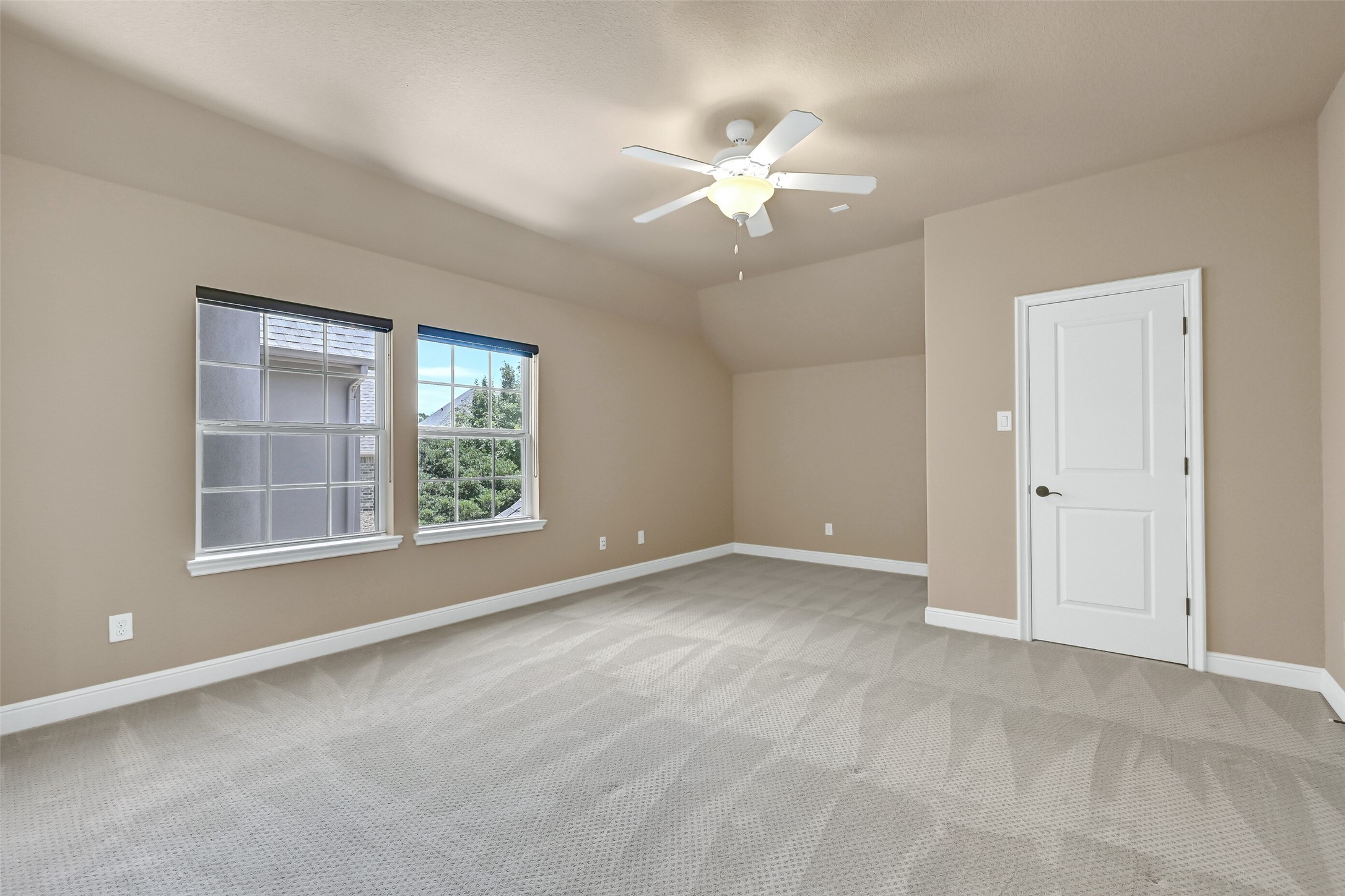 One of three spacious upstairs secondary bedrooms, this oversized retreat features plush carpet, elevated ceilings, abundant natural light, and a private en suite bath for added comfort and privacy.