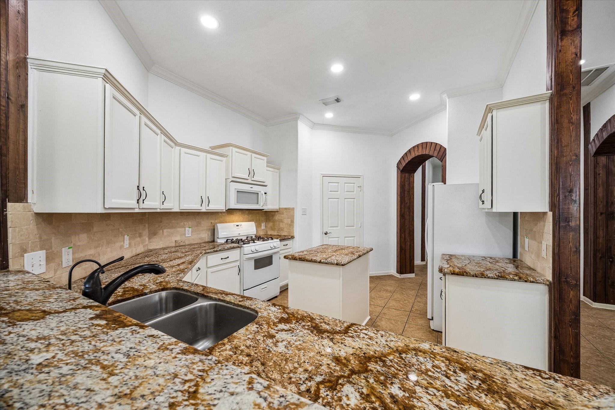 Experience culinary luxury in this kitchen with stunning granite countertops, a convenient water filter, and deep pot-filling sinks, perfect for modern living.