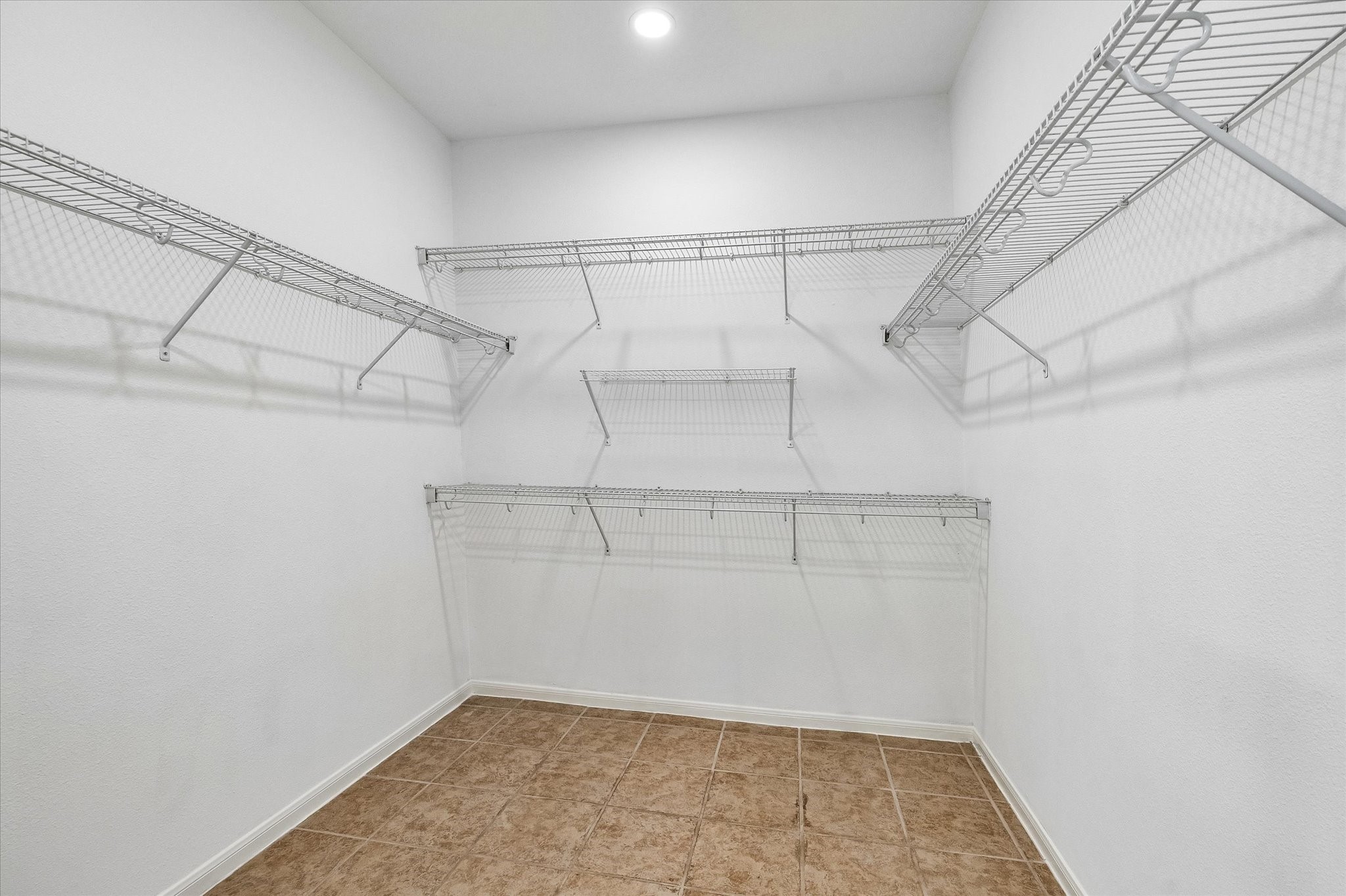 Spacious walk-in closet featuring sleek built-in shelves for effortless organization.