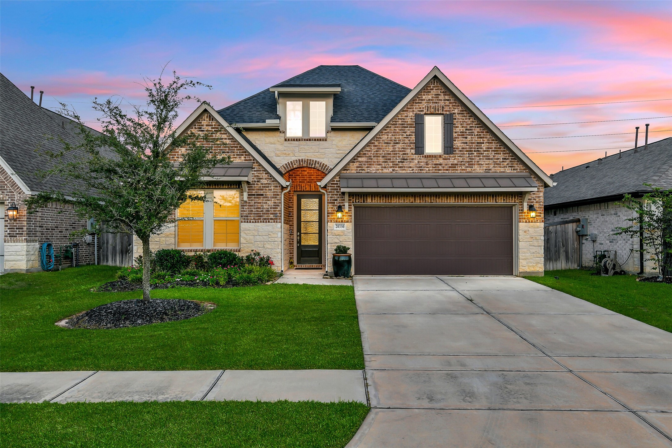 Mature landscaping in the front yard includes a beautiful full oak.