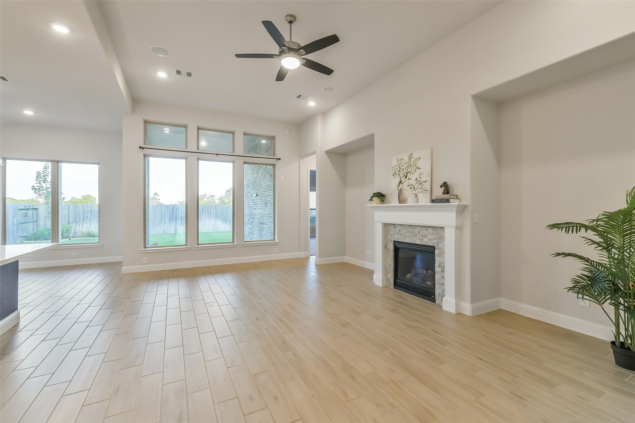 This living room features a gas fireplace, plenty of natural light and beautiful tile flowing throughout the living and kitchen areas.
