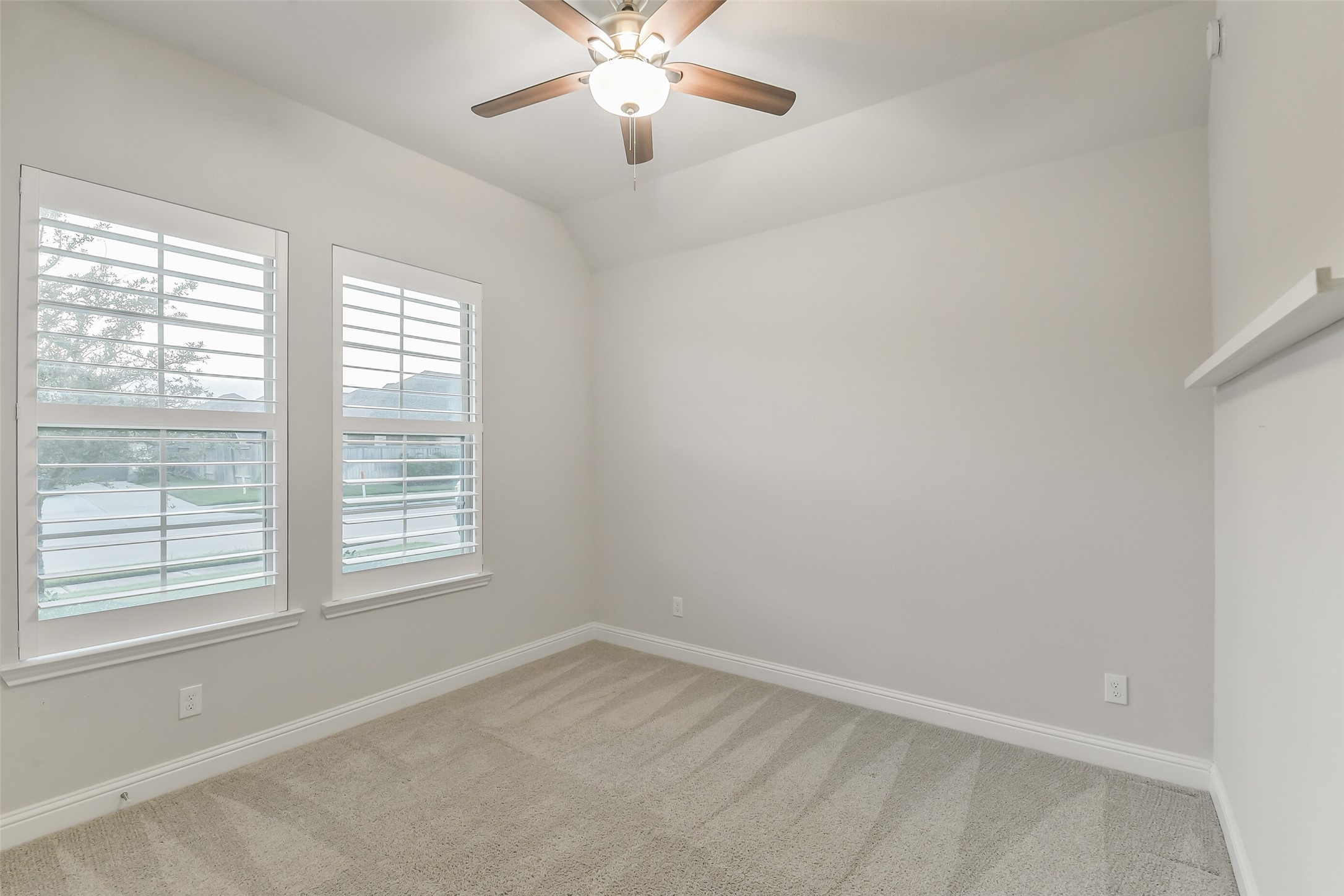 Secondary bedroom #2 with plantation shutters and ceiling fan