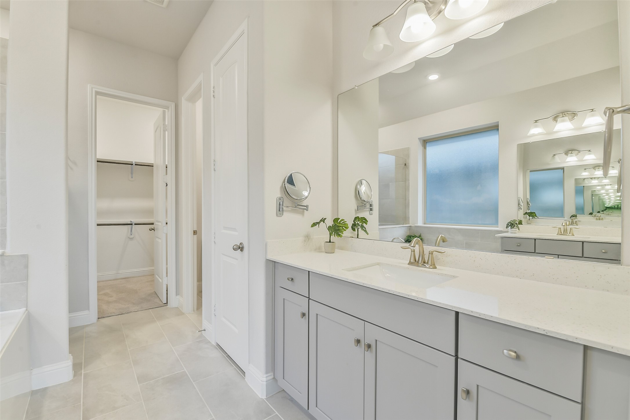 This primary bathroom features separate sinks with oversized countertops.