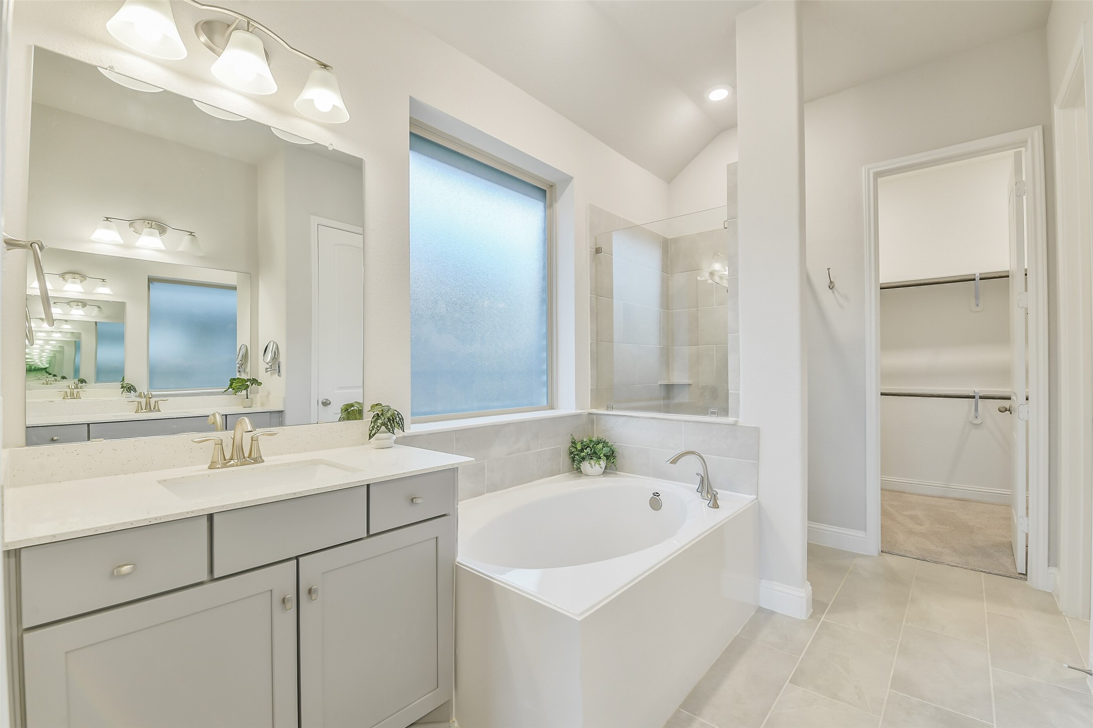 This large frosted window provides natural light in the primary bathroom.