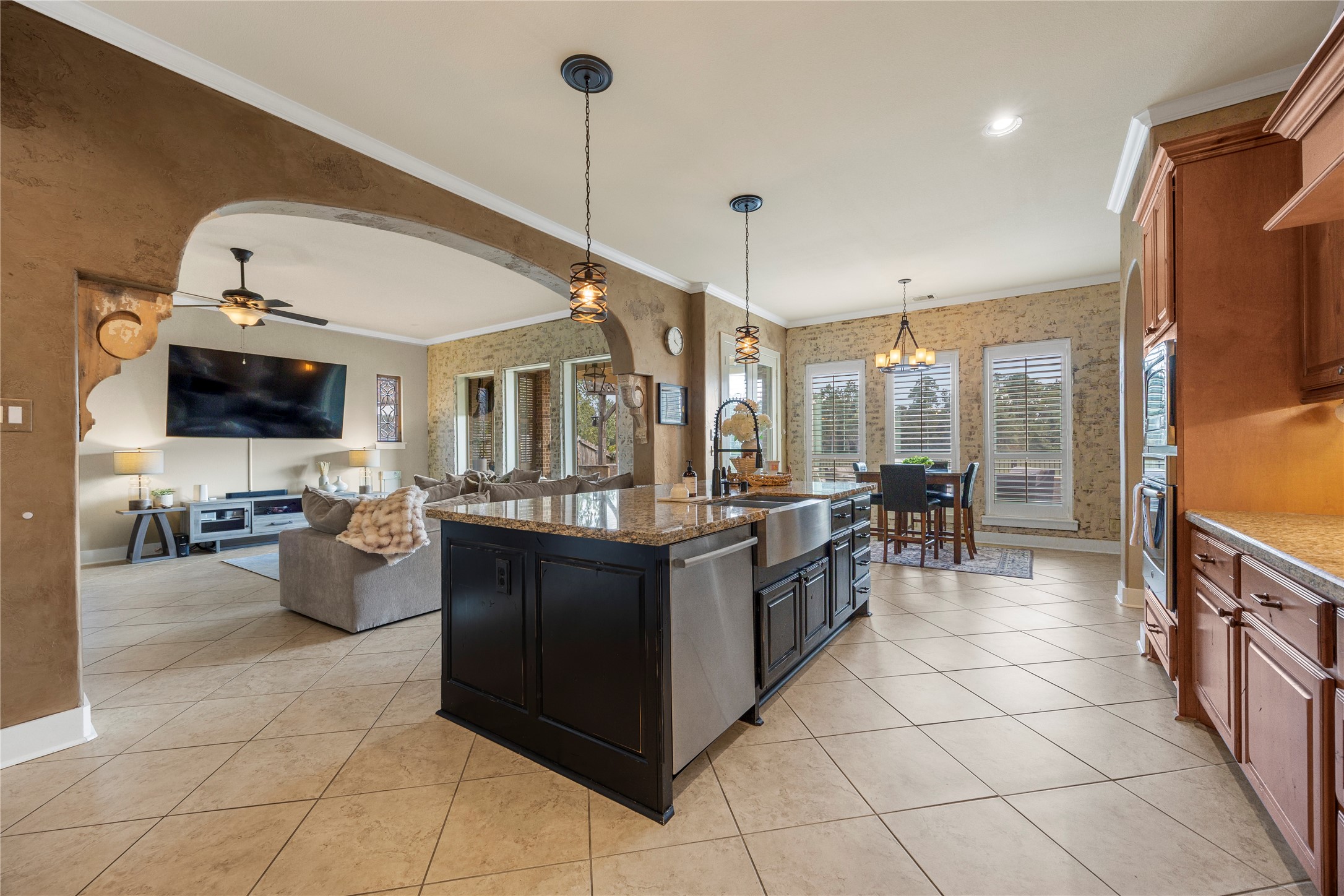 The oversized kitchen island anchors this open-concept space, seamlessly connecting the kitchen, breakfast area, and family room.