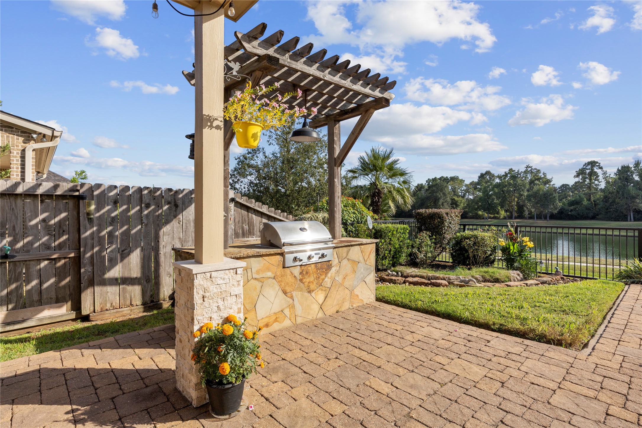 Built-in outdoor grill with stone surround and wooden pergola, creating the perfect setting for backyard cookouts and entertaining.