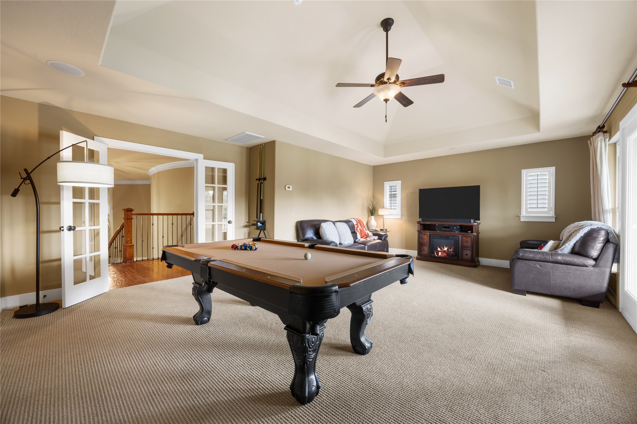 Entertainment central! This oversized upstairs game room offers plenty of space for a pool table, comfortable seating, and movie nights. French doors provide an elegant entrance.