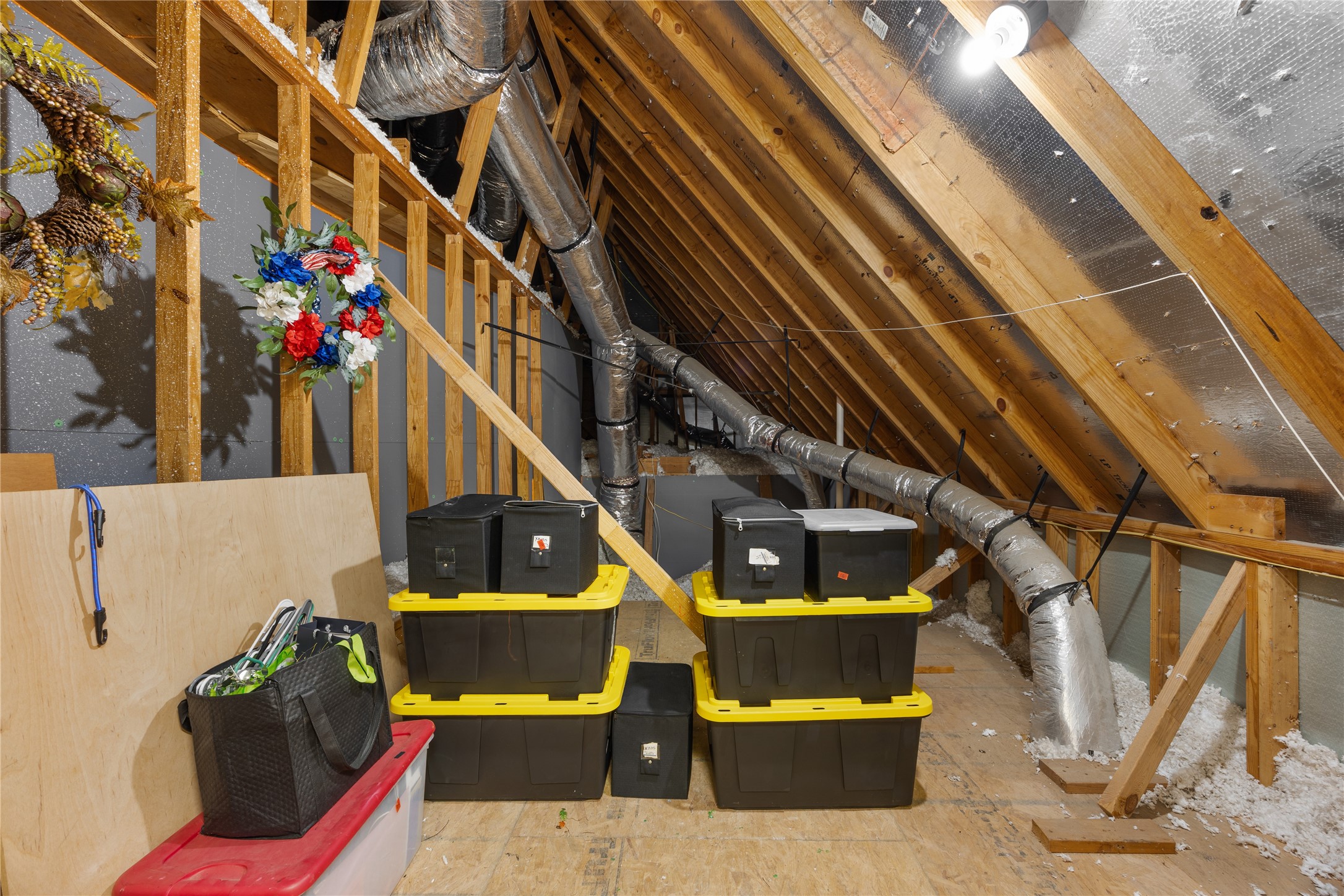 One of two additional attic storage spaces with wood decking, lighting, and room to keep seasonal decorations and household items organized.