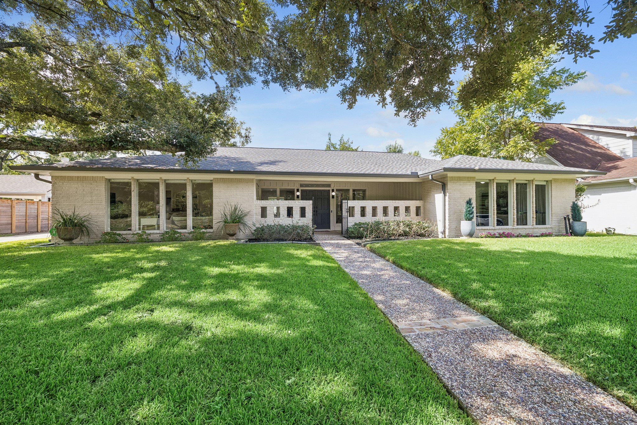 The oak tree shades the front lawn nicely, while the floor to ceiling windows allow natural light to flood the home. The oak tree shades the front lawn nicely, while the floor to ceiling windows allow natural light to flood the home.