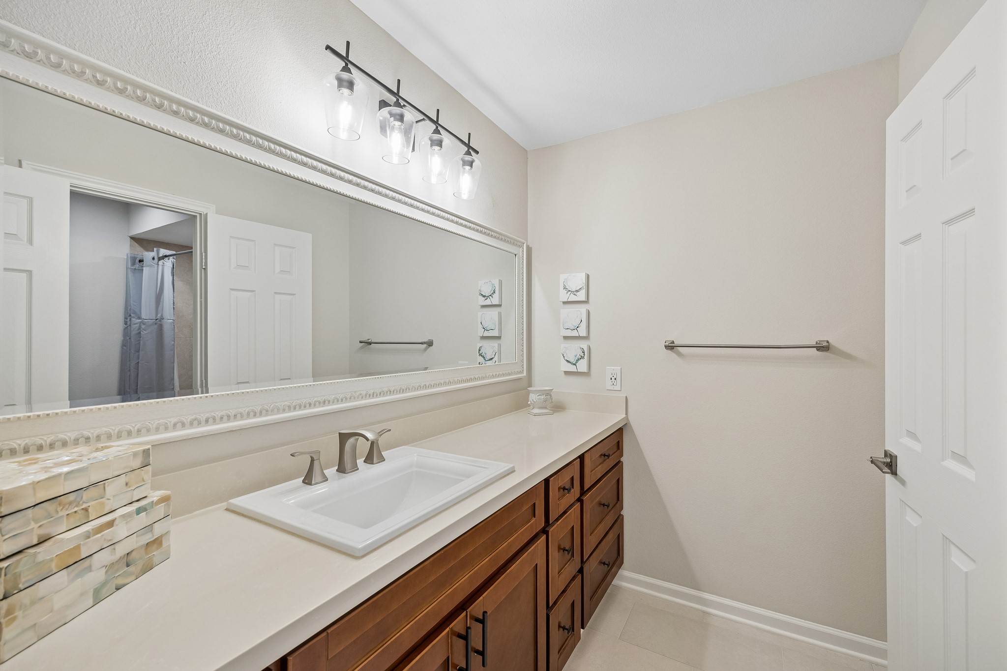 The hall bathroom features a spacious vanity with a large countertop, generous cabinetry, and an expansive mirror. Through the privacy door is the tub/shower combo, toilet, and a dedicated linen closet.