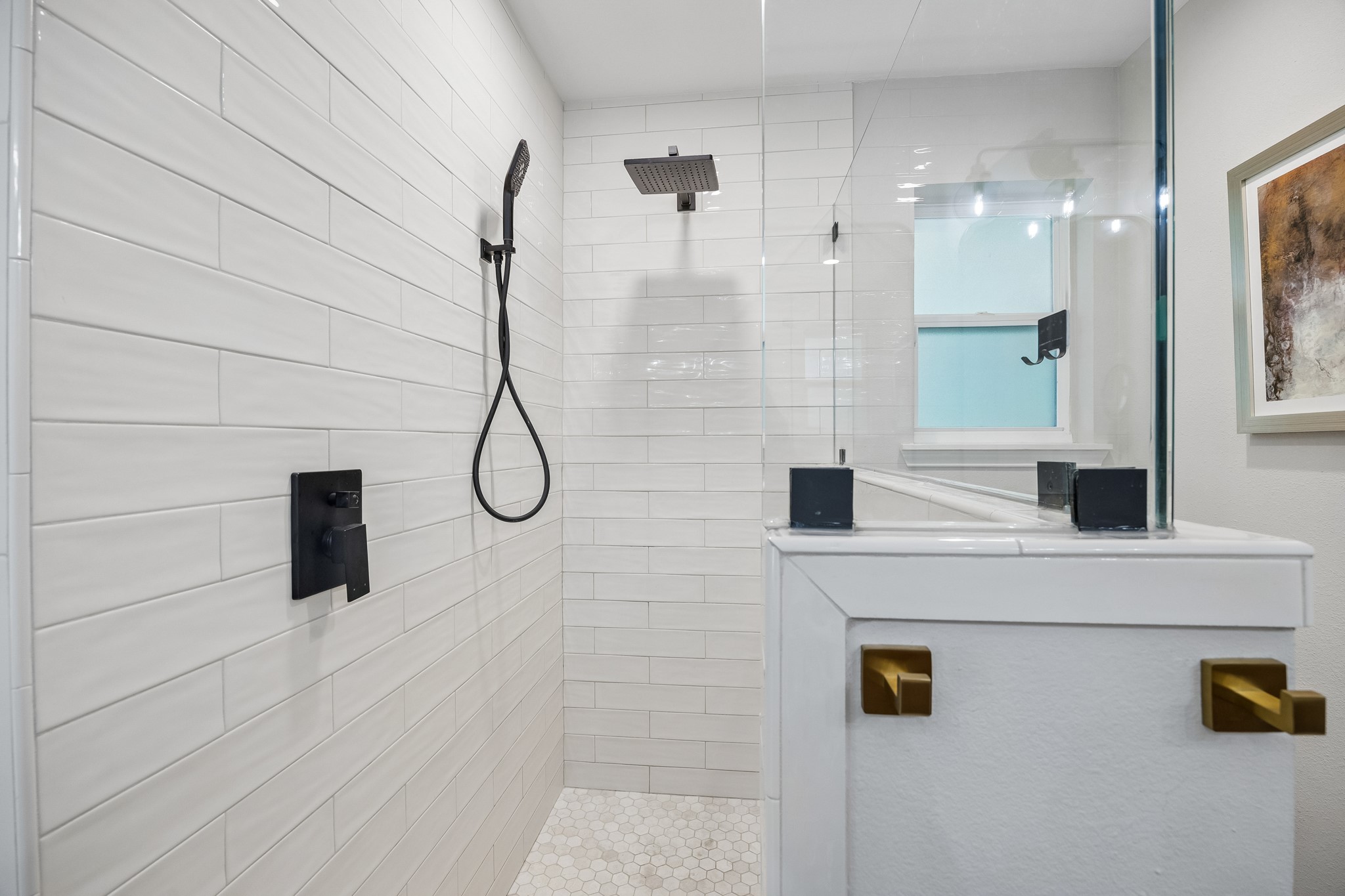 Walk-in shower is equipped with both a rainfall showerhead and a handheld sprayer.