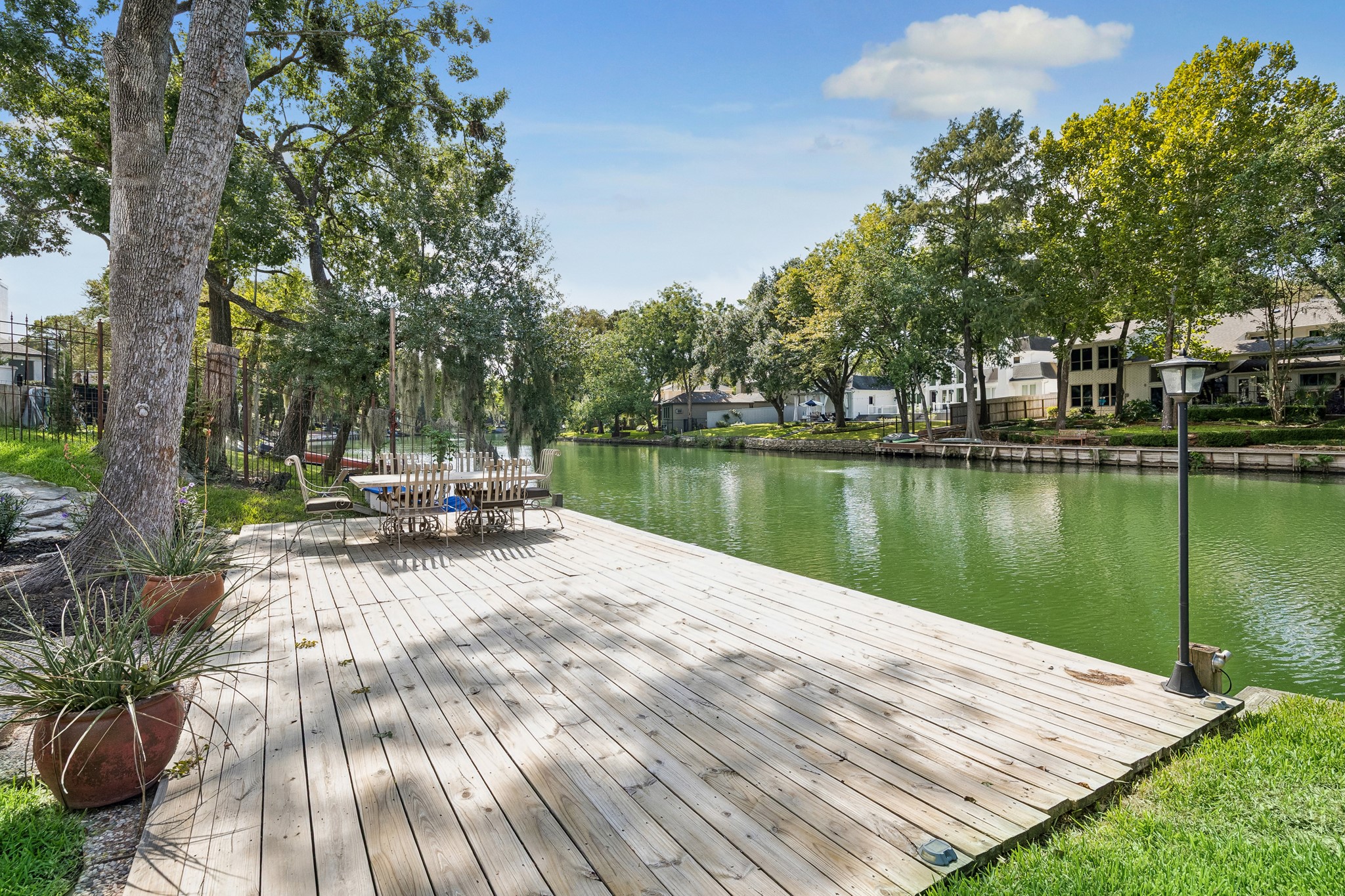 An expansive wood deck extends to the water's edge, offering a wonderful setting for outdoor dining, relaxing, and entertaining, with a serene backdrop.