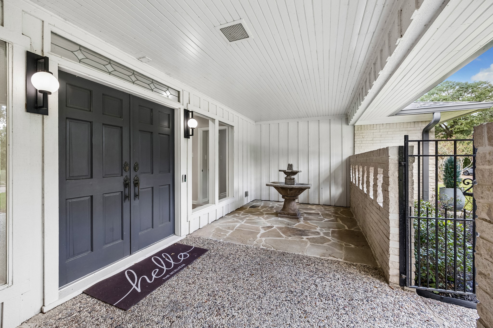 An enclosed gated porch with double entry doors and generous plate glass windows makes this space feel like part of the indoors and part of the outdoors. An enclosed gated porch with double entry doors and generous plate glass windows makes this space feel like part of the indoors and part of the outdoors.