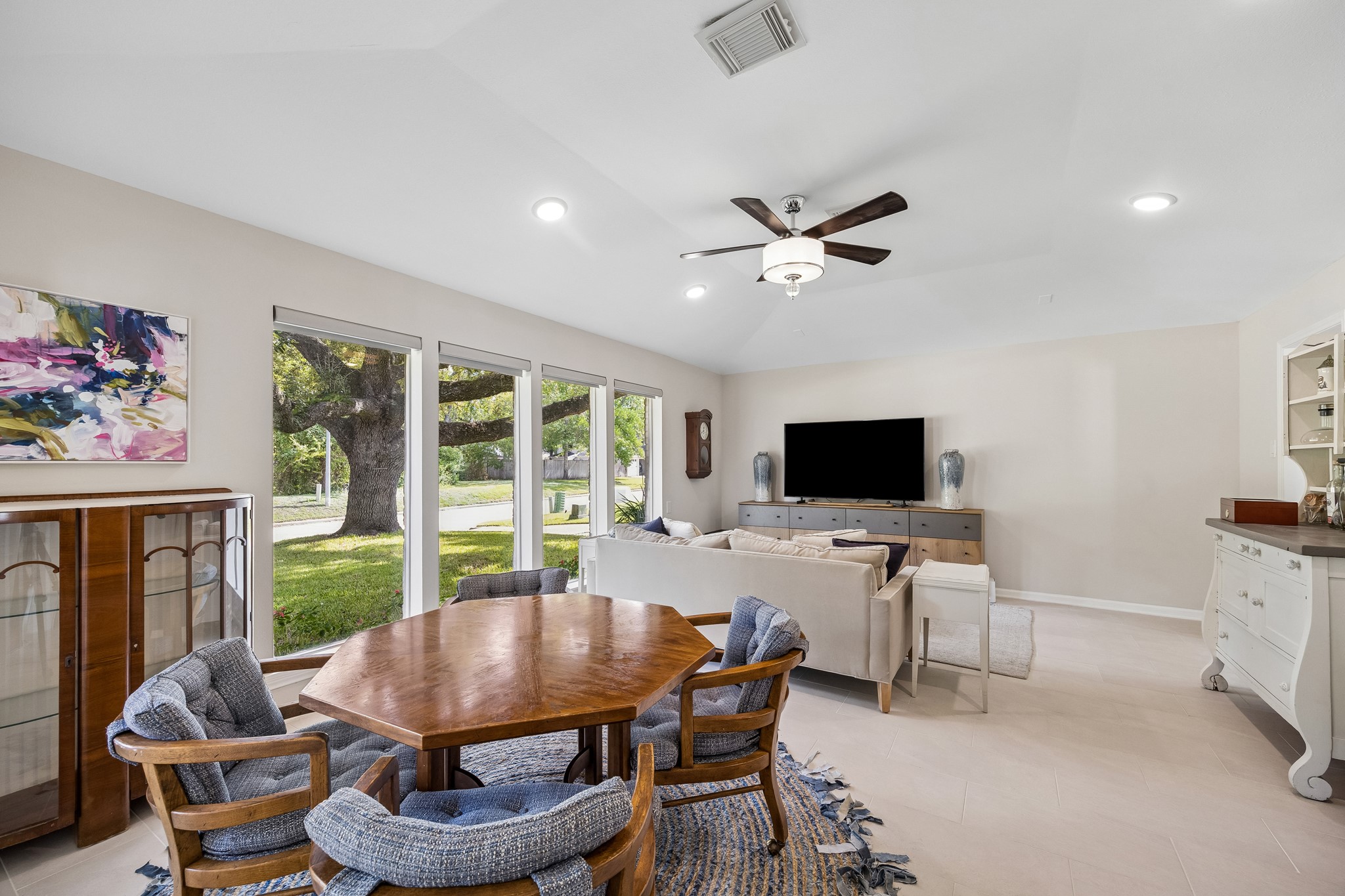 Originally designed as formal living and dining rooms, this spacious area is currently used as a game room and den. A high ceiling and large windows showcase the beautiful oak tree views, while the open layout offers flexibility for entertaining.