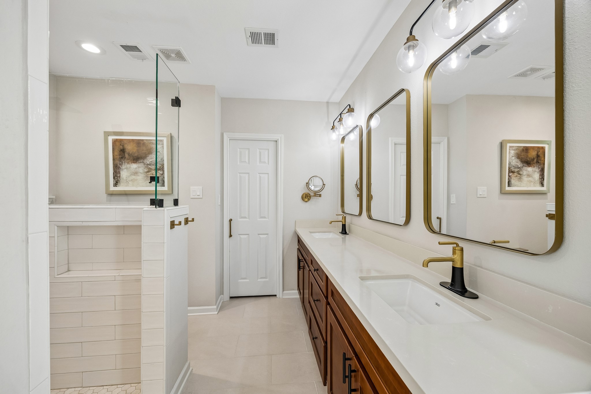 Additional view of the Primary Bath highlights the extended vanity and modern fixtures. The door at the end leads to the larger of two Primary Closets.