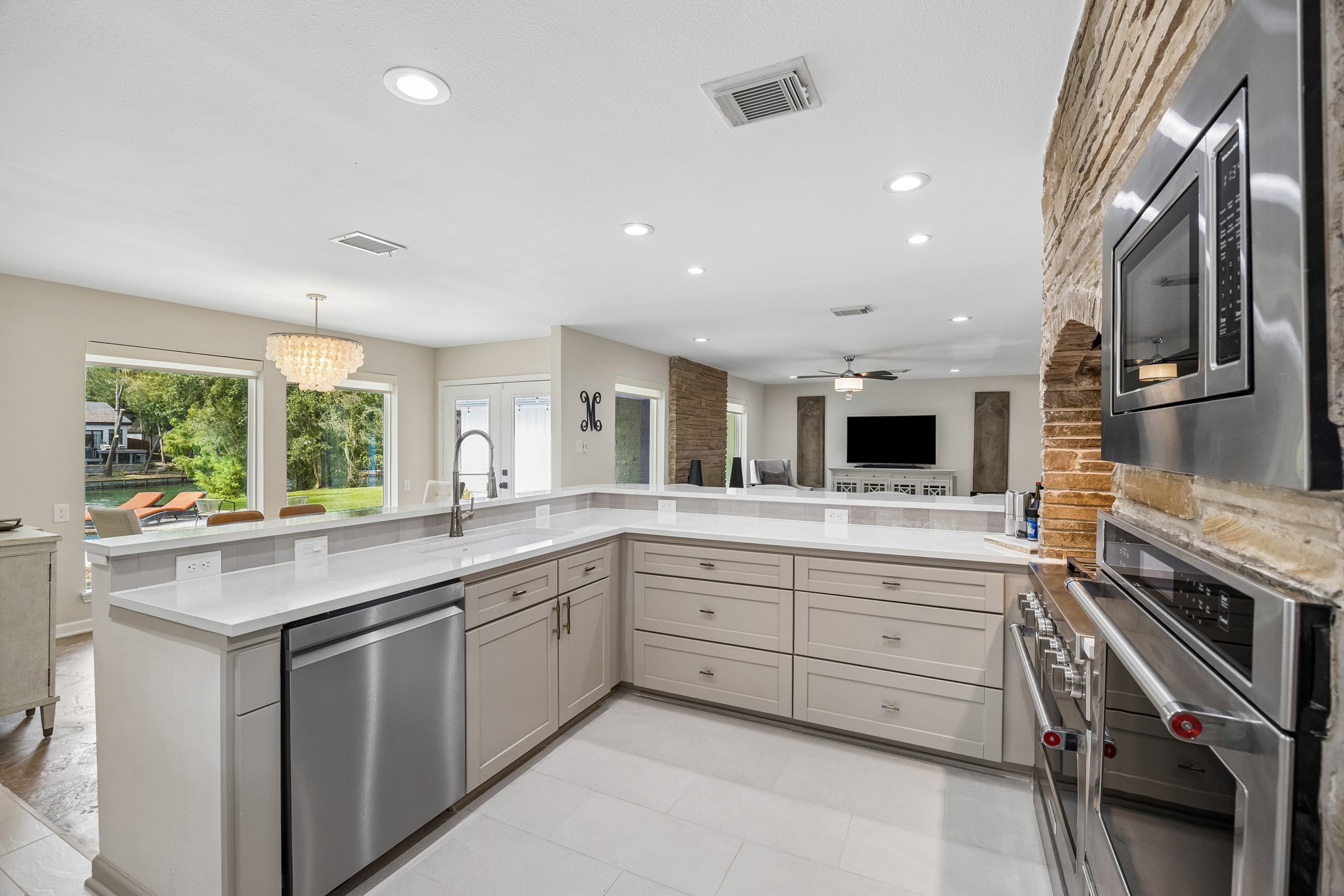 Expansive quarts countertops provide abundant workspace, complemented by a large single-basin sink, and oversized drawers perfect for pots and pans, and bulky kitchen essentials.