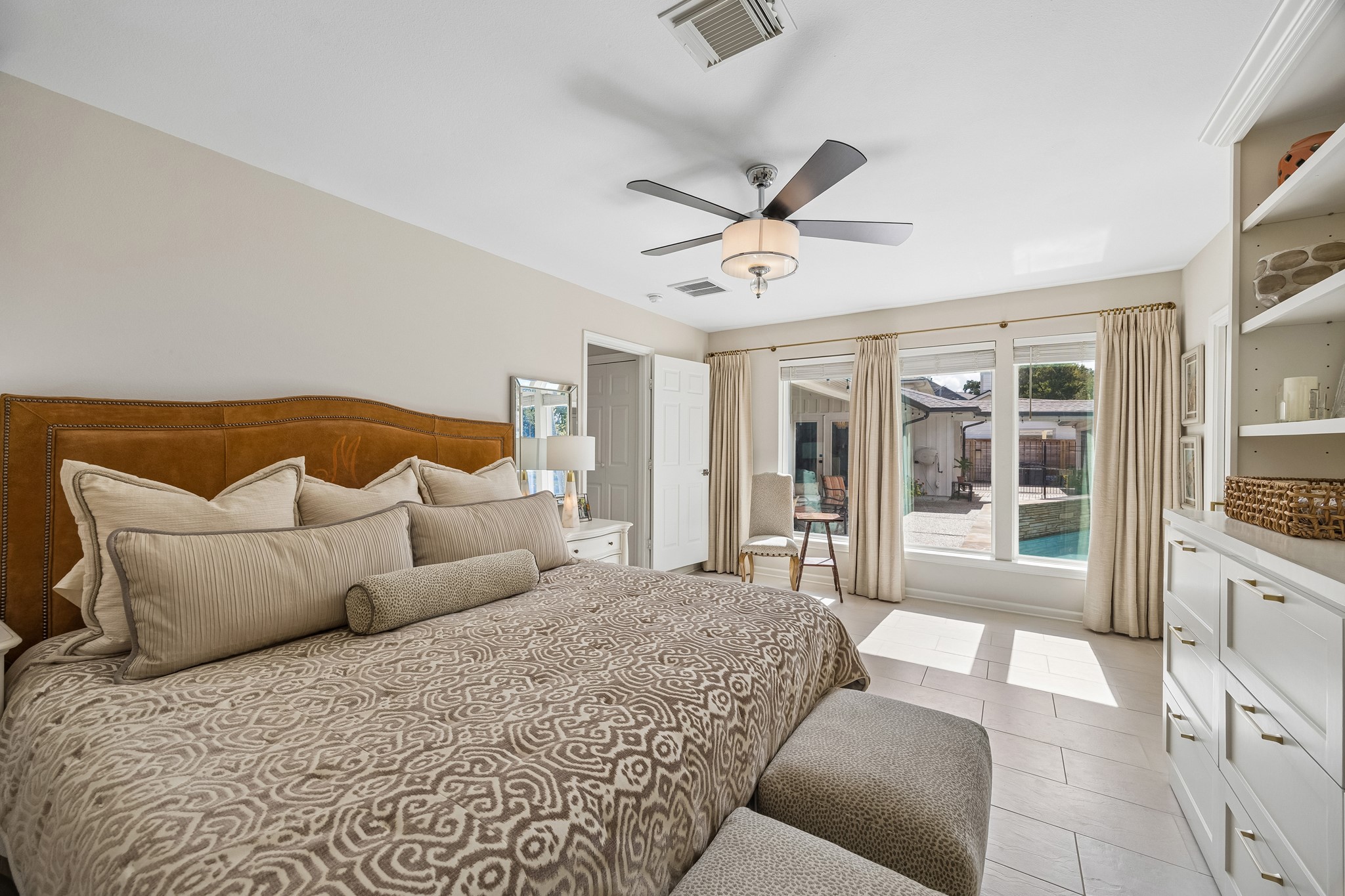 Spacious Primary Bedroom featuring large windows overlooking the pool. Abundant natural light creates a relaxing atmosphere.