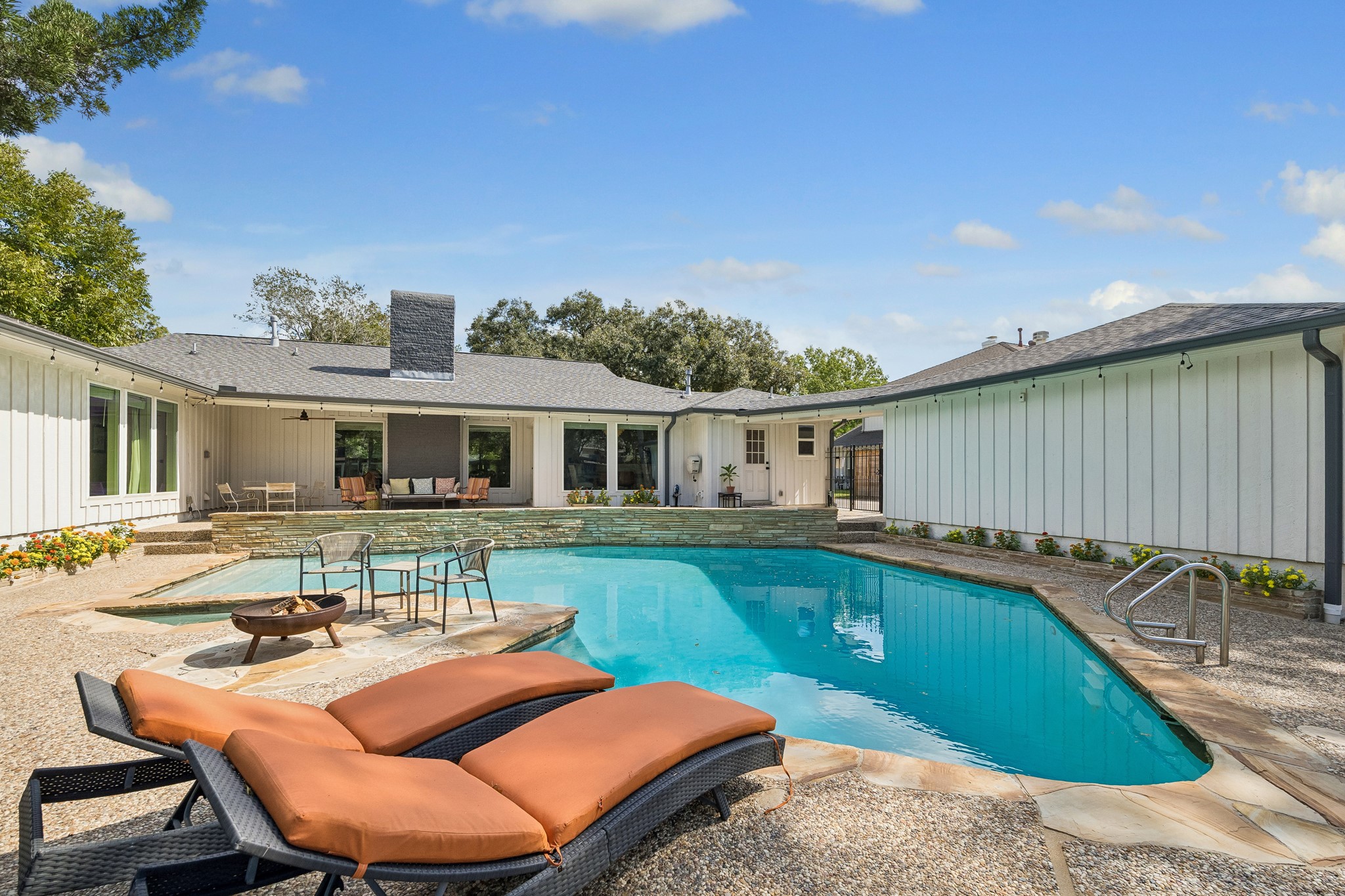 The stacked stone continues to the backyard surrounding the expansive pool and the planters on either side. The pool was replastered in 2022.