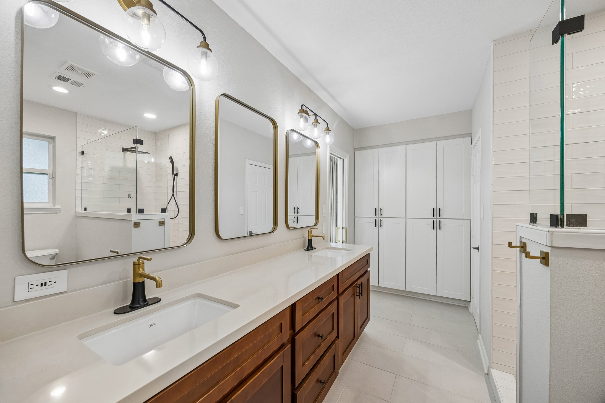 Spacious Primary Bath featuring dual sinks and generous storage. Clean lines, warm wood cabinetry, and modern fixtures create a stylish retreat.