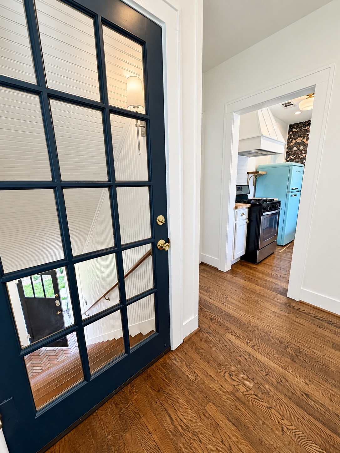 Private upstairs entry with a beautiful glass-paneled door, hardwood floors, and direct access to the kitchen.