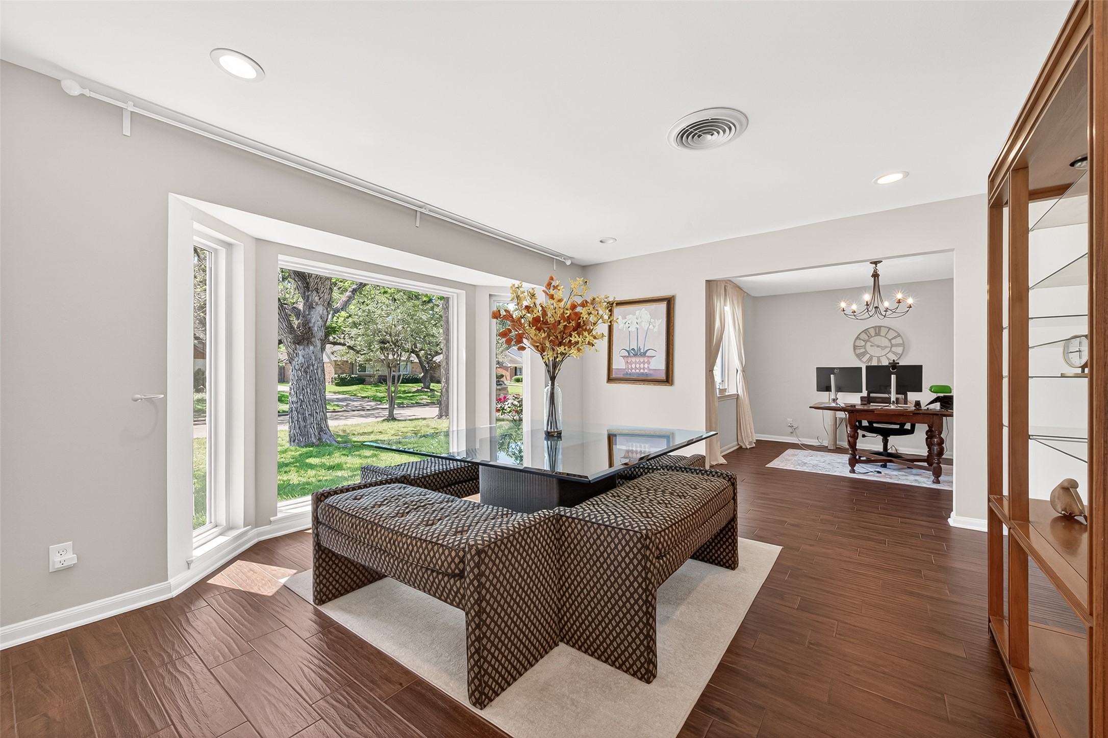 Elegant formal living room positioned at the front of the home, featuring large bay windows that flood the space with natural light and create a warm, inviting atmosphere perfect for entertaining or everyday living.