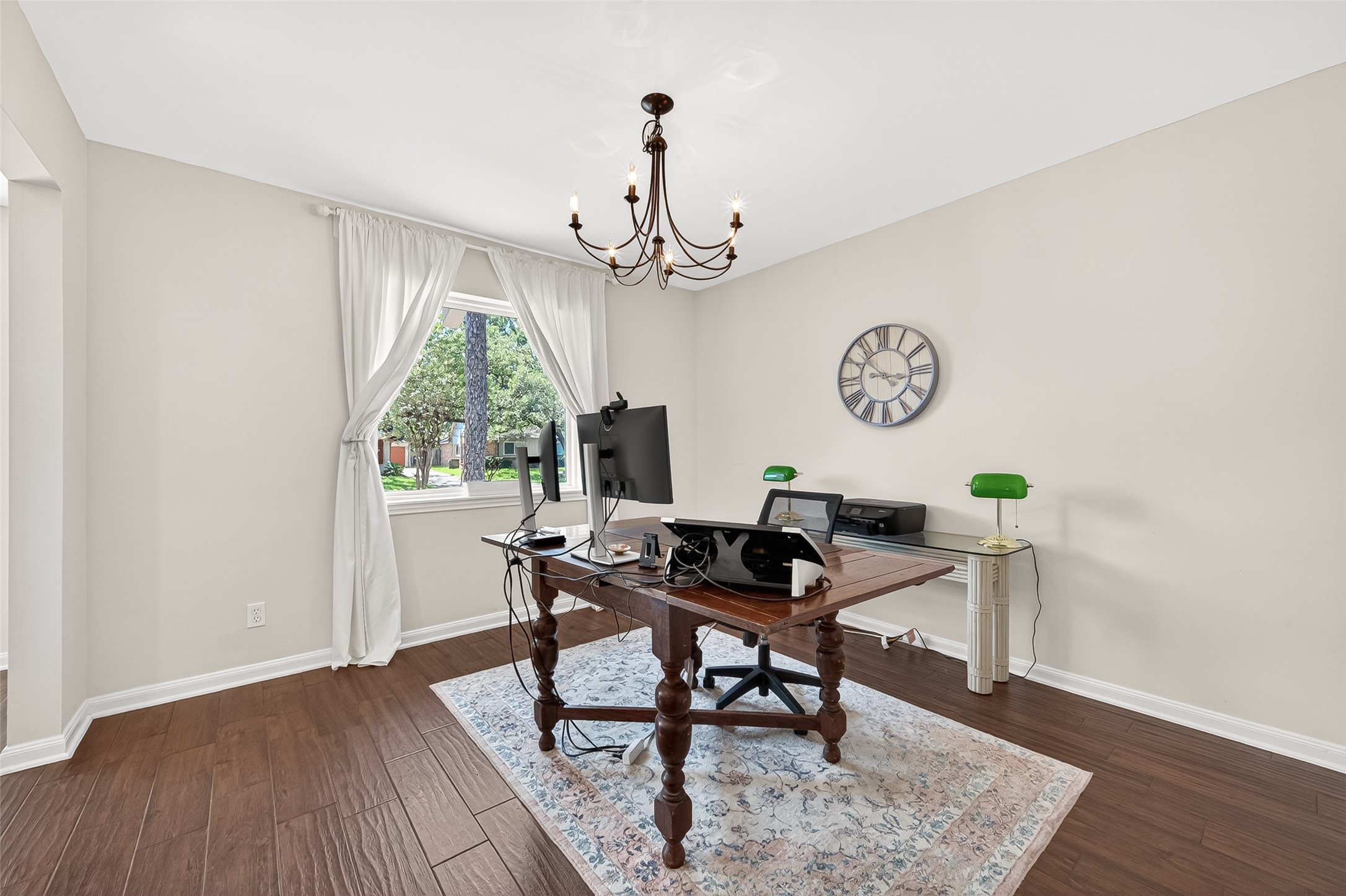 This room is currently being used as an office but is a great flex space for a playroom or even to relocate the dining room. Large window and classic chandelier.