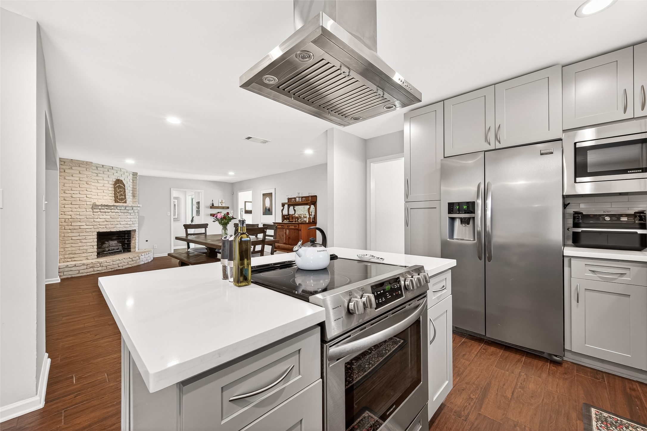 The cozy brick fireplace is visible in the adjacent living space, enhancing the inviting atmosphere.