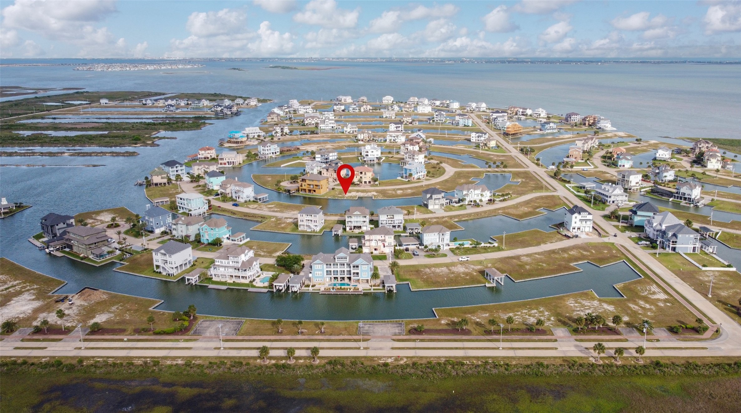 From the neighborhood entrance looking toward West Bay and the Intracoastal Waterway, the pin highlights the prime location of this waterfront lot within Harborwalk.