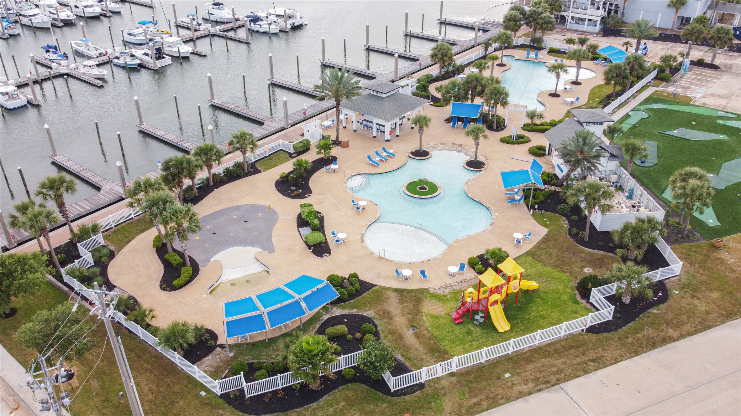 The Harborwalk community offers an impressive variety of amenities, including this entertainment area with two pools, a splash pad, pool bar, playground, and putt-putt golf course beside the full-service 156-slip marina with a ship store, fuel, bait shop, deli, boat ramp, lodge, and event center.
