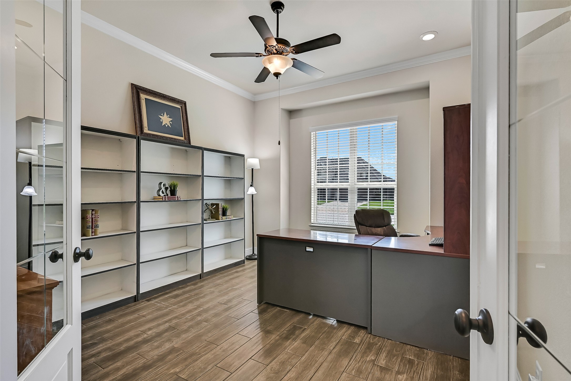Working from home is a pleasure in this spacious study, complete with French doors, crown molding, recessed lighting, a ceiling fan, and a large front-facing window with 2-inch blinds. This versatile space also works beautifully as a library, hobby room, or quiet retreat.