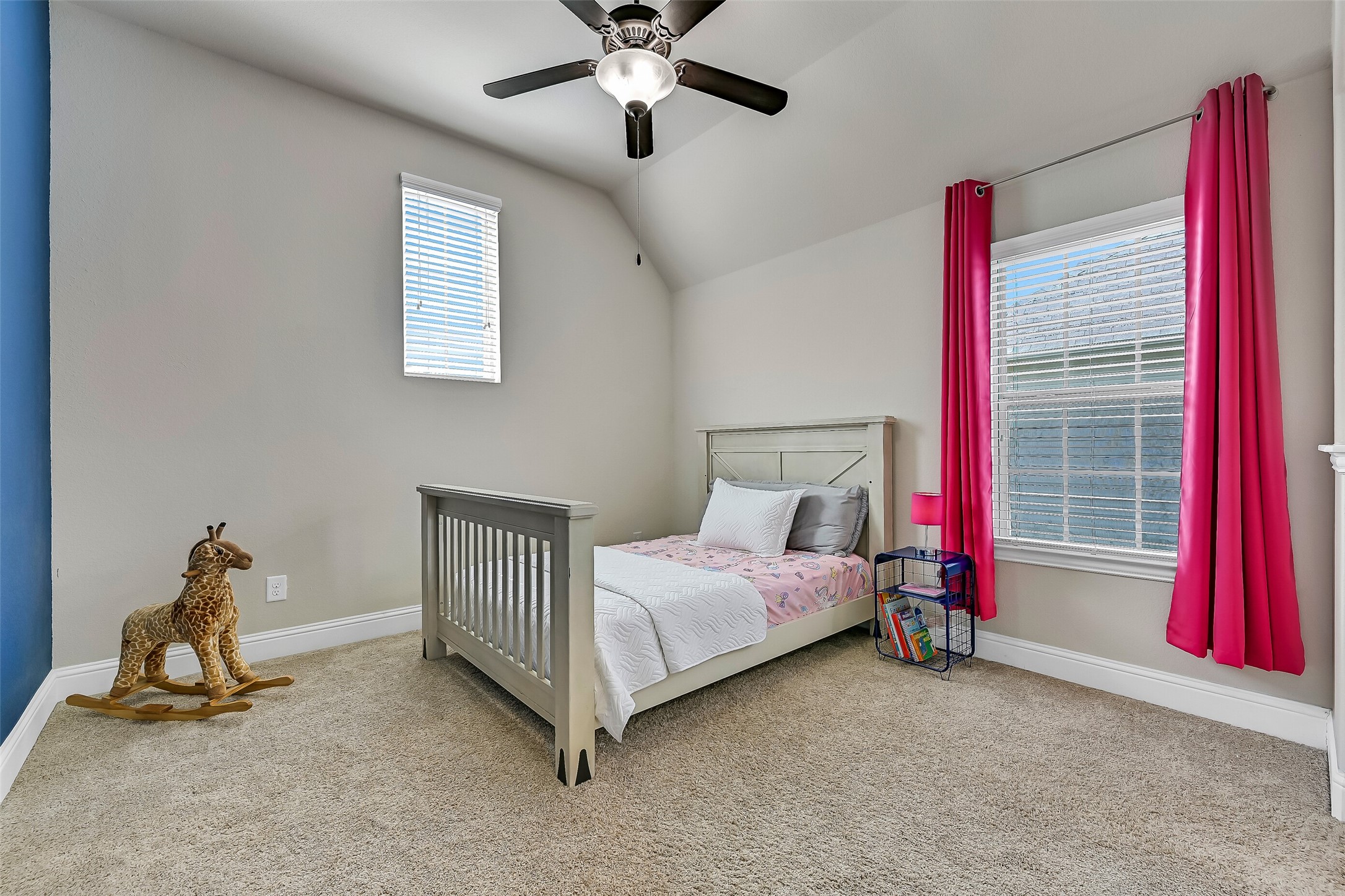 One of two spacious bedrooms connected by a Jack-and-Jill bath, this inviting room features plush carpeting, a vaulted ceiling, a lighted ceiling fan, and windows that fill the space with natural light. A step-in closet provides plenty of everyday storage.