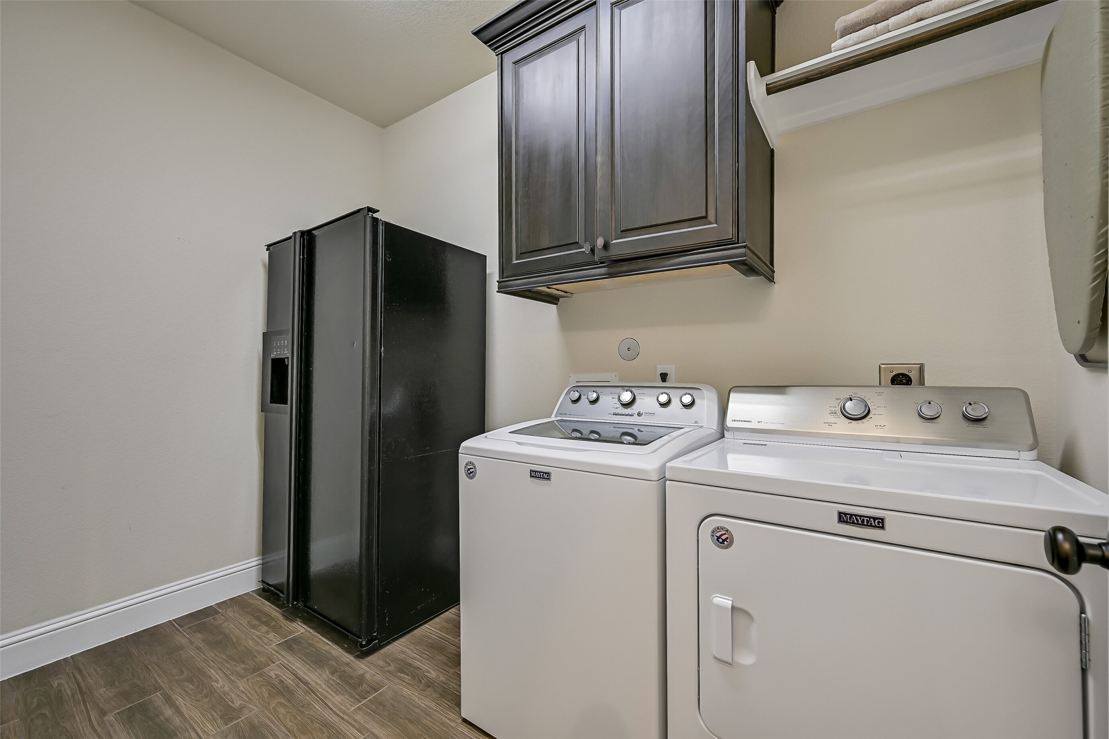 Conveniently located just off the kitchen, the spacious utility room offers upper cabinetry, gas and electric dryer connections, and dedicated space for an additional refrigerator or freezerproviding everyday functionality with extra storage where it matters most.