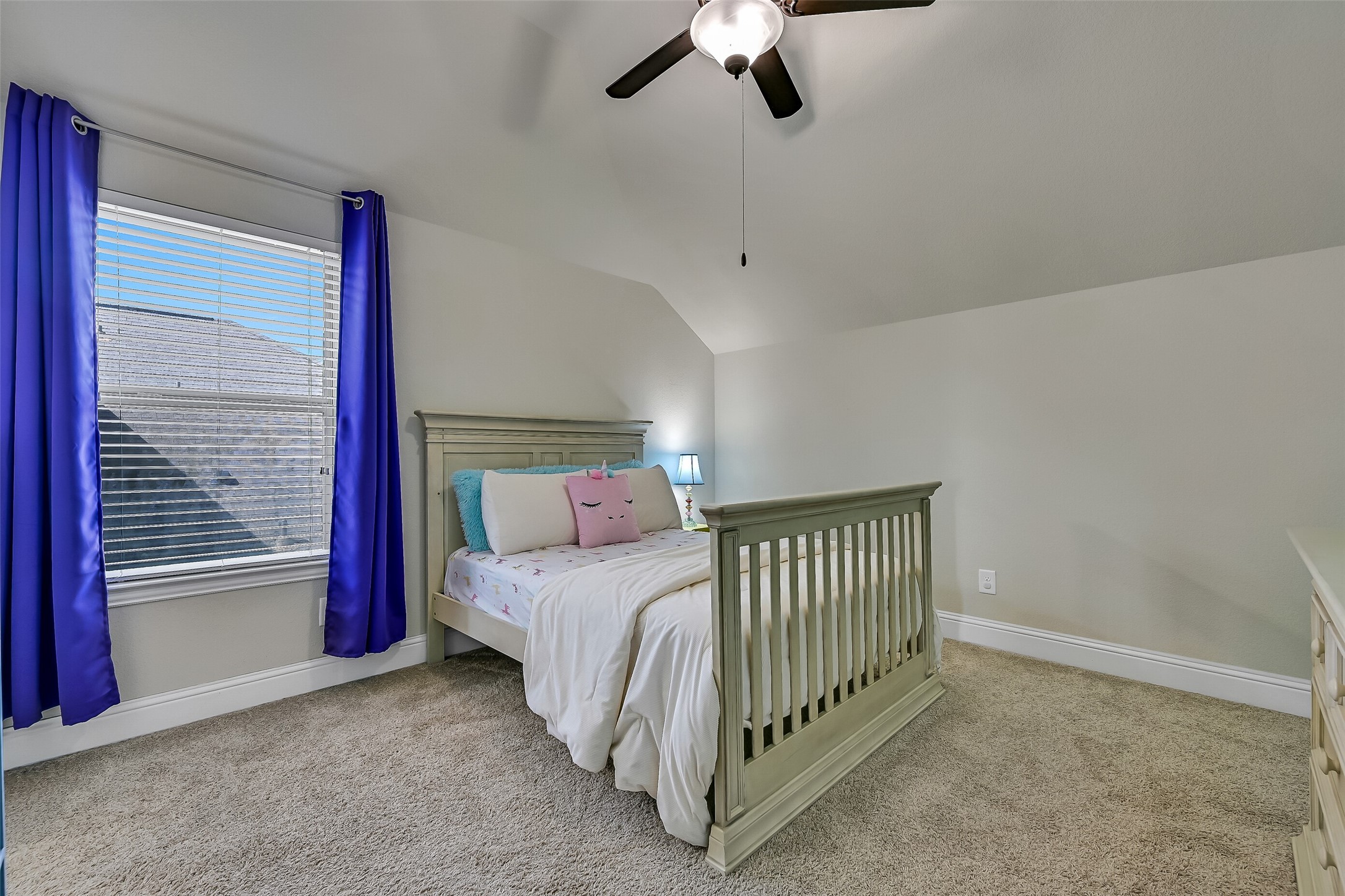 Located on the opposite side of the Jack-and-Jill bath, this spacious secondary bedroom offers plush carpeting, a vaulted ceiling, a lighted ceiling fan, and a large window that fills the room with natural light. A step-in closet provides ample storage while the adjoining bath offers added convenience.