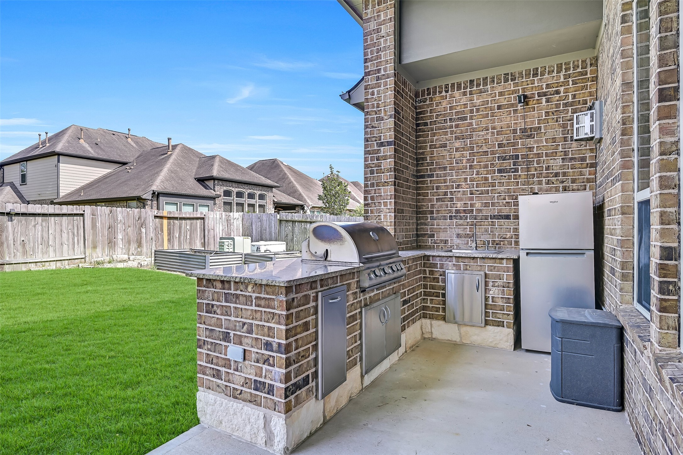 Weekend cookouts are effortless with the covered outdoor kitchen featuring granite countertops, a built-in 5 burner gas grill, sink, refrigerator, pull out trash, and convenient storage. Everything you need is right at your fingertips while overlooking the spacious backyard.