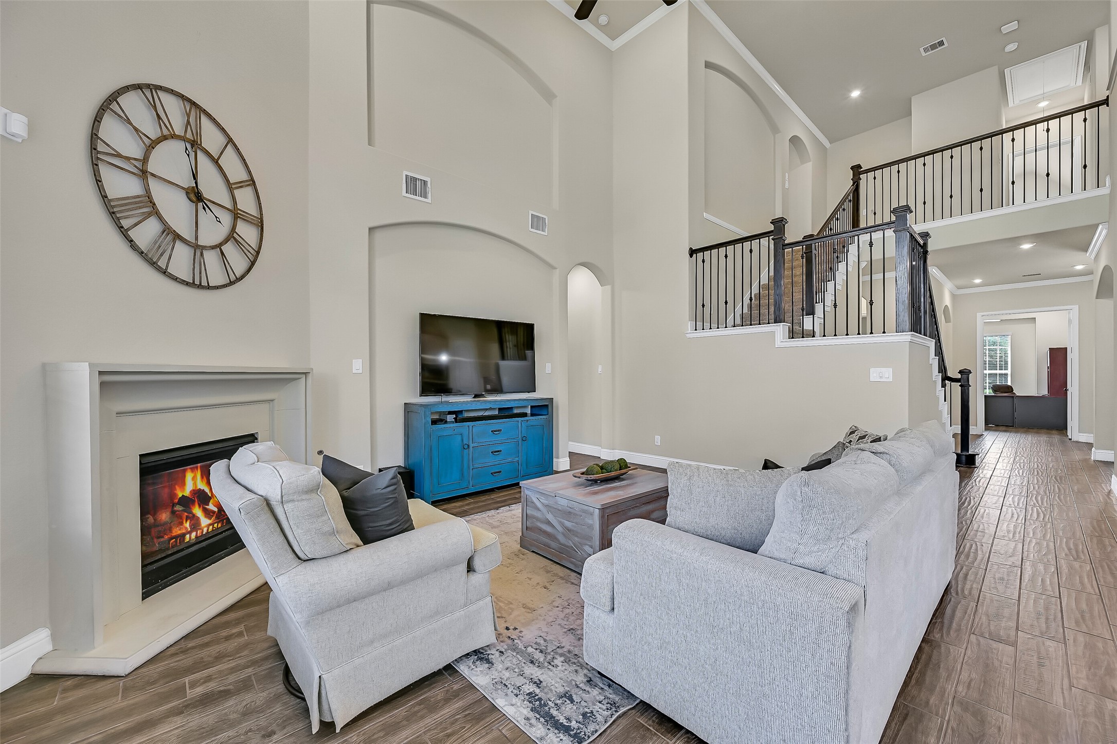 Twenty-foot ceilings, dramatic art niches, and a wall of oversized windows create an incredible sense of openness in the family room. A cast stone gas log fireplace anchors the space while the open-concept design keeps everyone connected to the kitchen and breakfast area.
